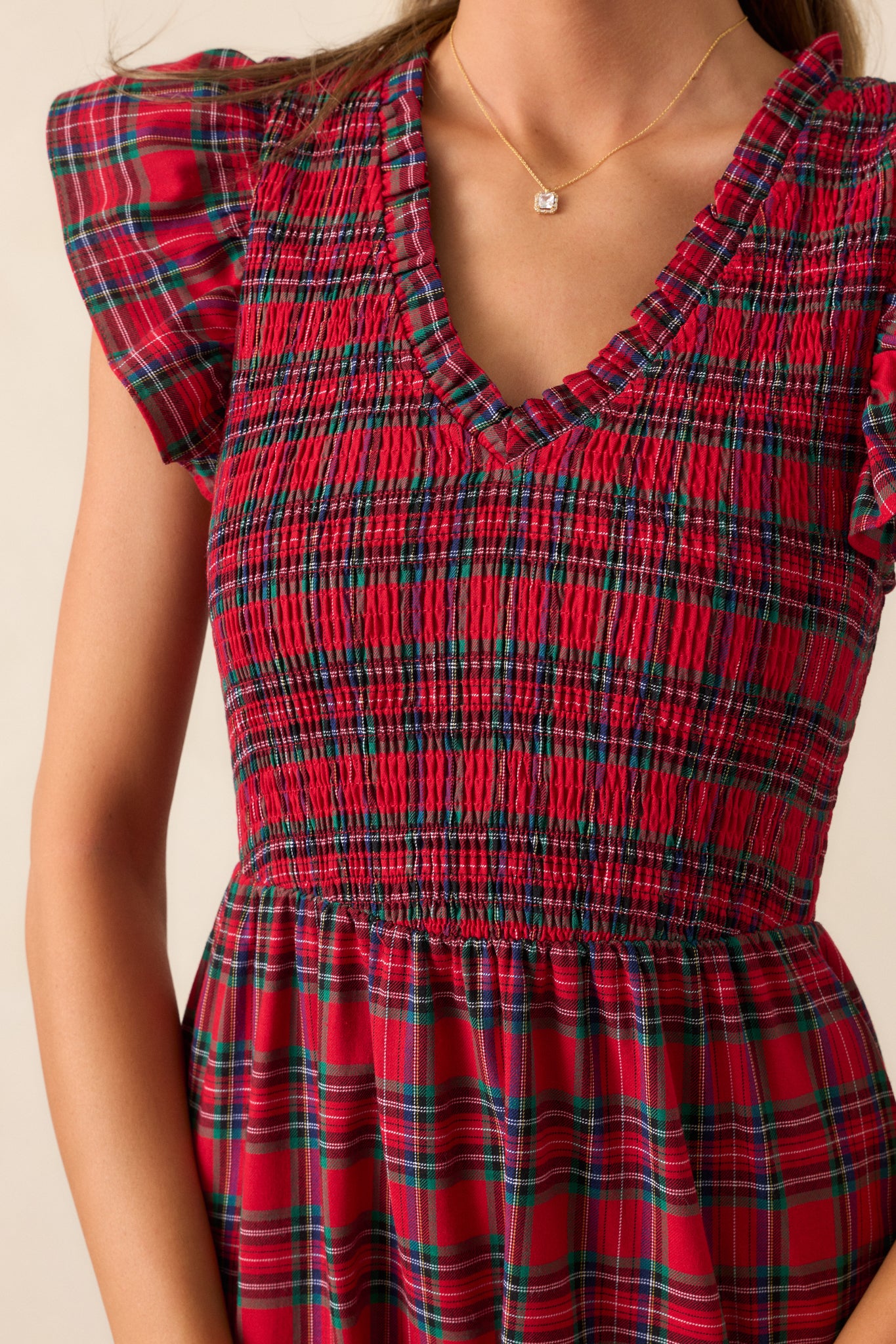 Close-up of the smocked bodice, showcasing the texture, plaid pattern, and flutter sleeve detailing.