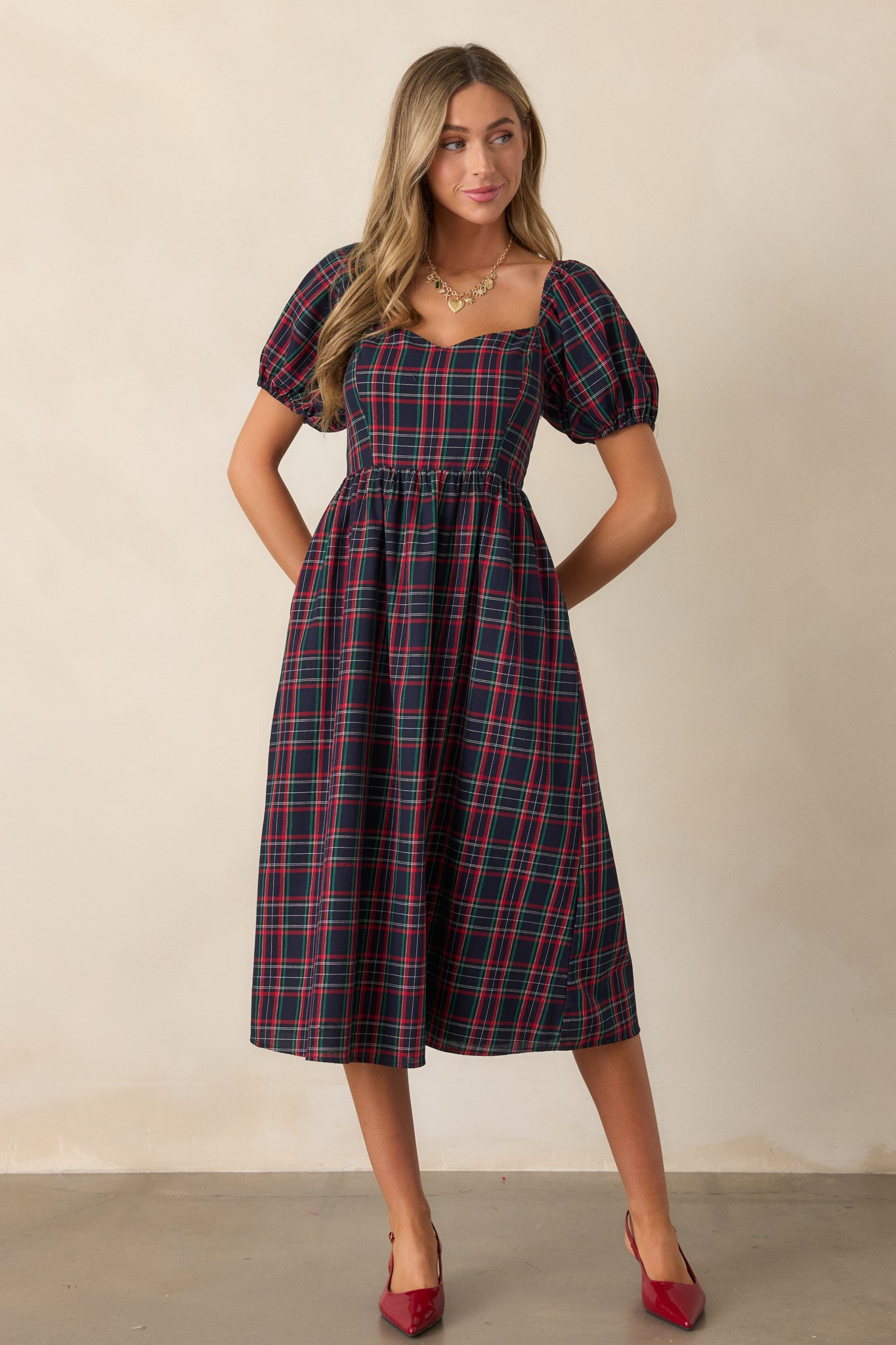 Full-length shot of the navy dress showcasing the fit, plaid pattern, and puff sleeve detail.