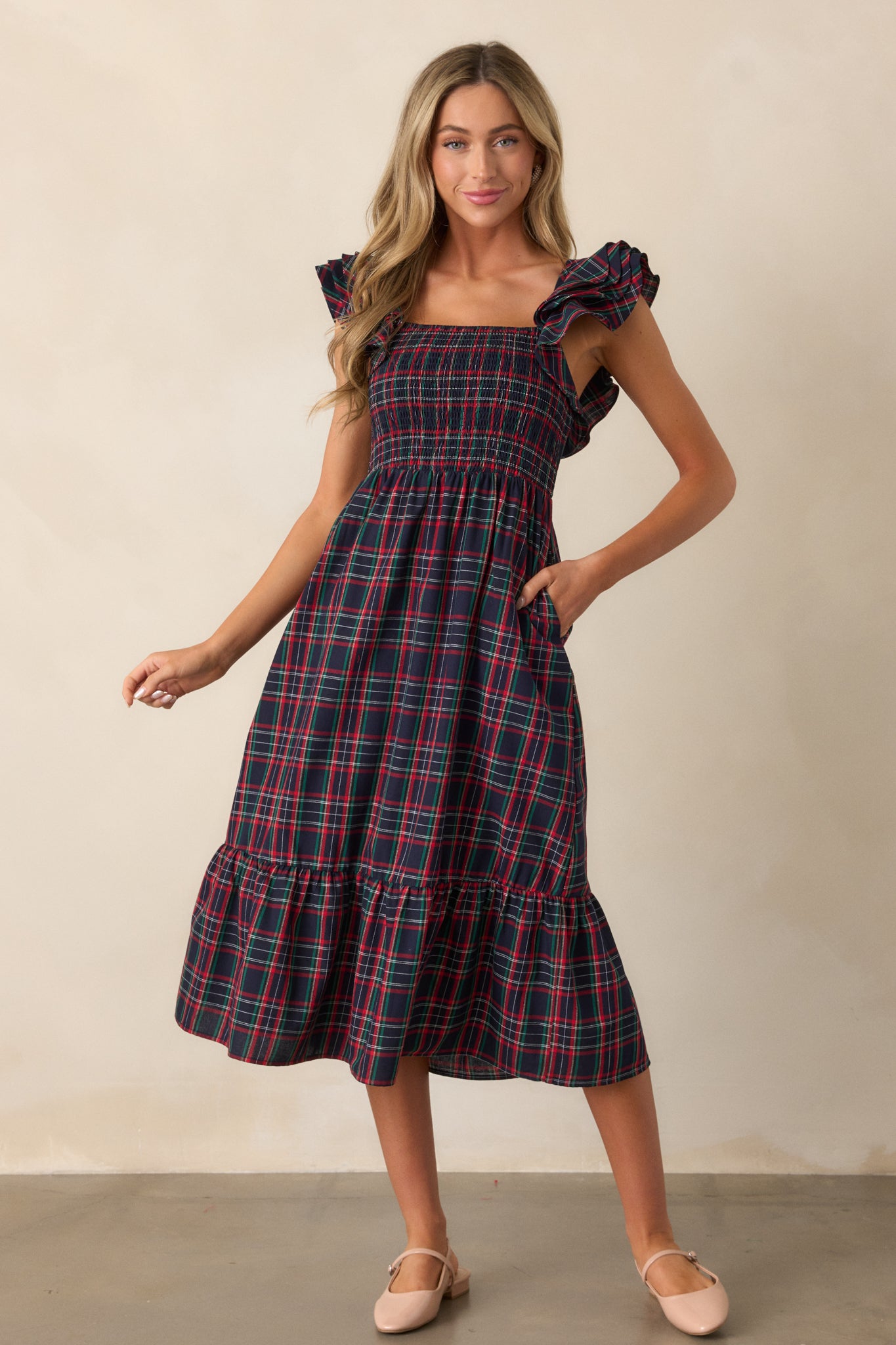 Front view of the navy dress emphasizing the plaid print and flowy tiered skirt design.