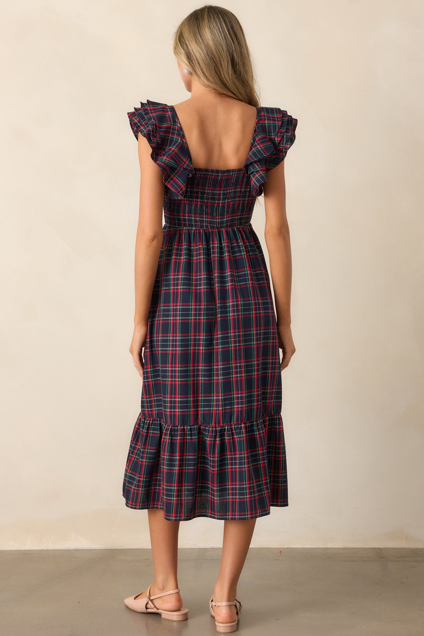 Back view of the navy dress, showing the continuation of the plaid print and the layered tiers of the skirt.