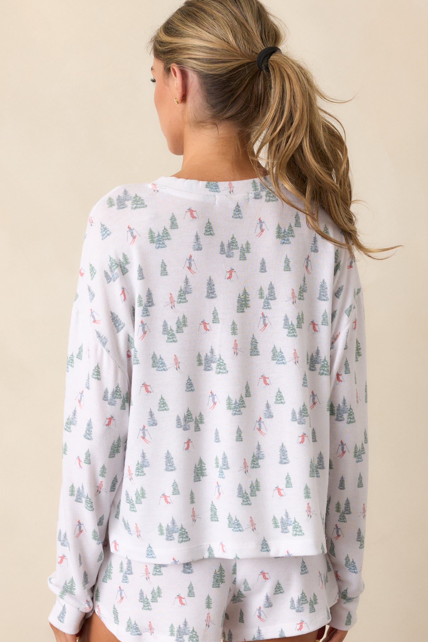 A back view of the ivory top, featuring the long sleeves and simple design, with the relaxed fit and crew neckline clearly visible.