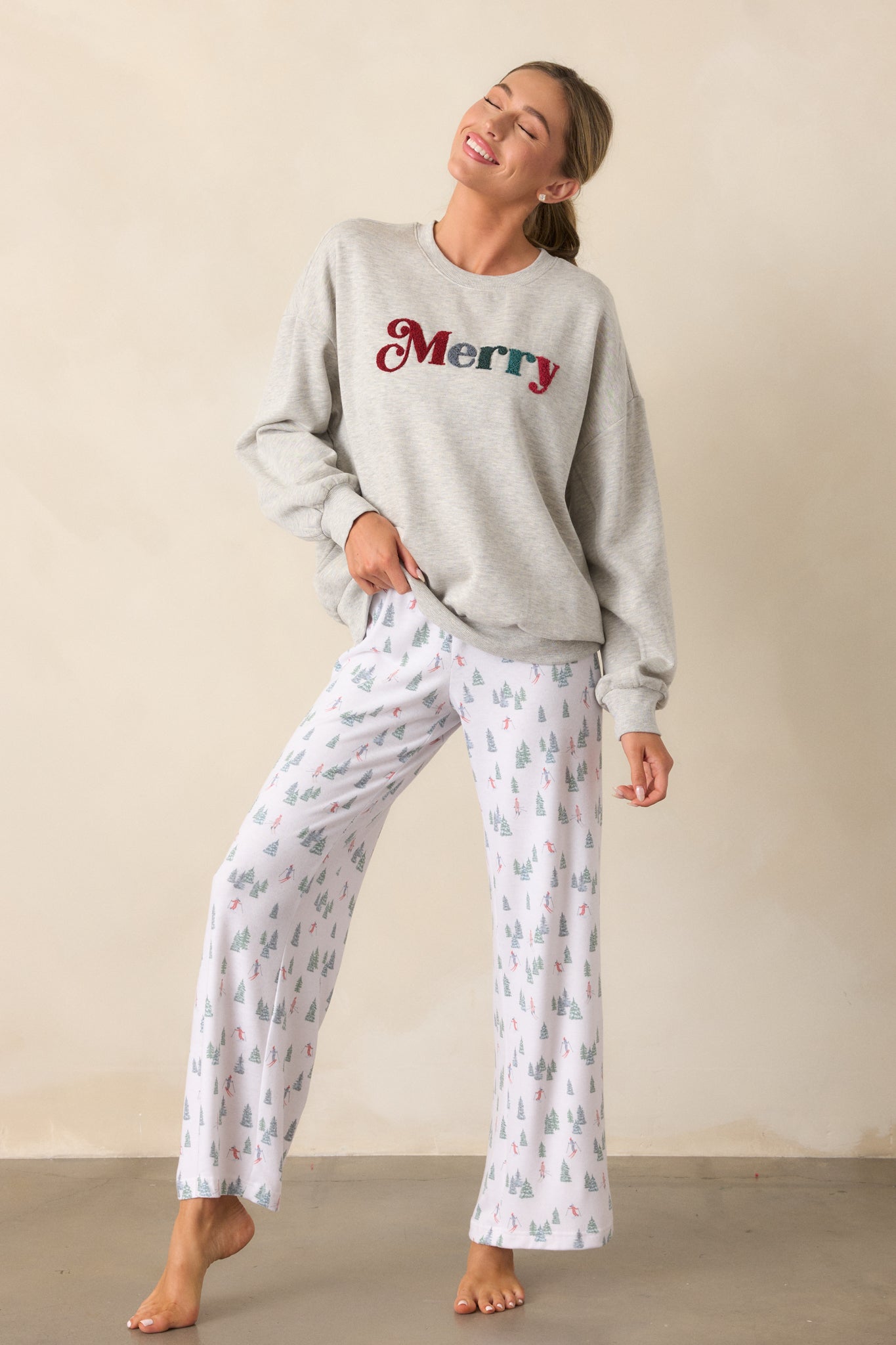 Another front view of the ivory pants highlighting the relaxed fit, high-rise smocked waistband, and the alpine skier pattern that runs the length of the pants.