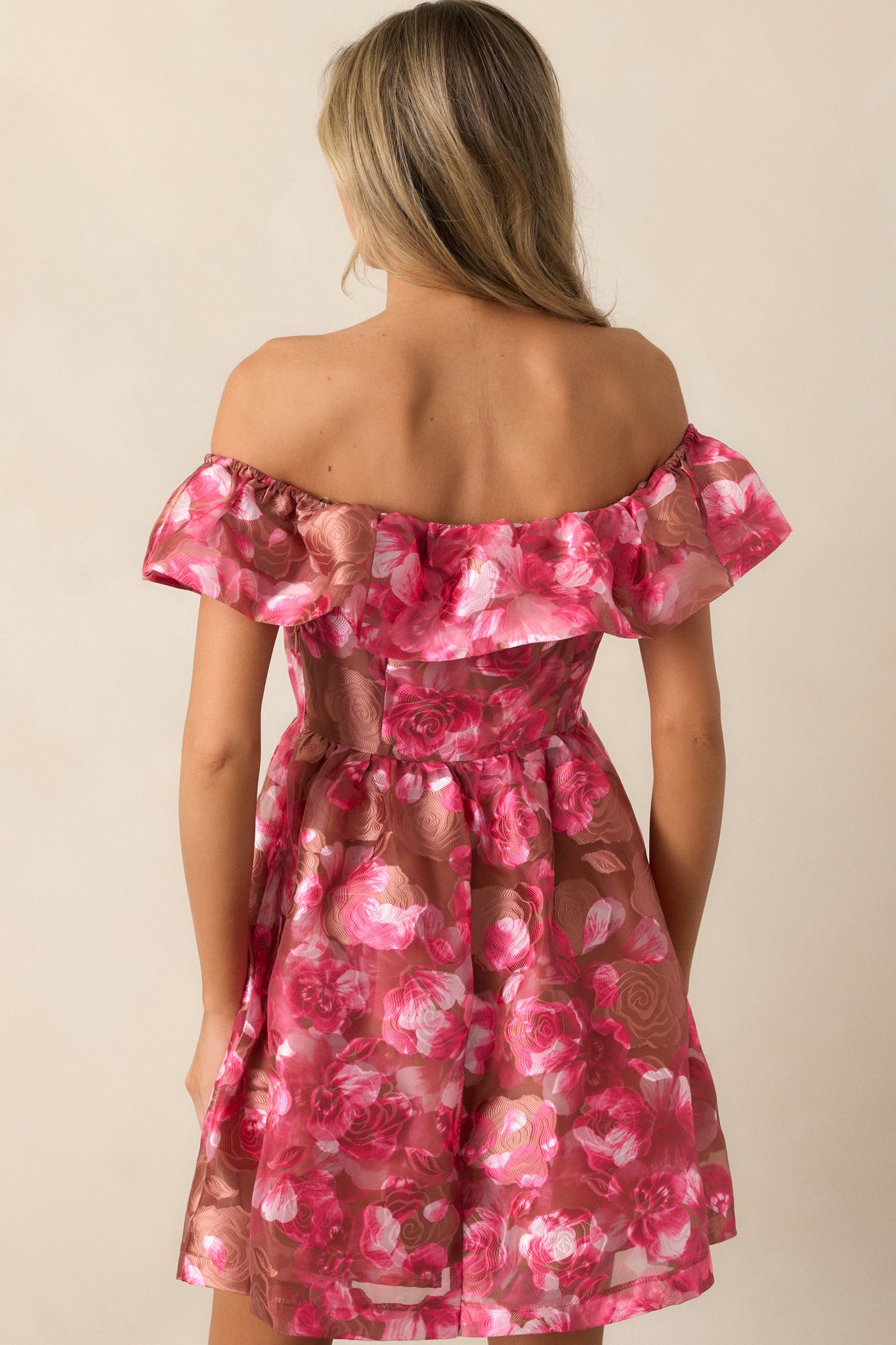 The back of the camel mini dress, displaying the babydoll silhouette and the gentle flow of the ruffle detail.