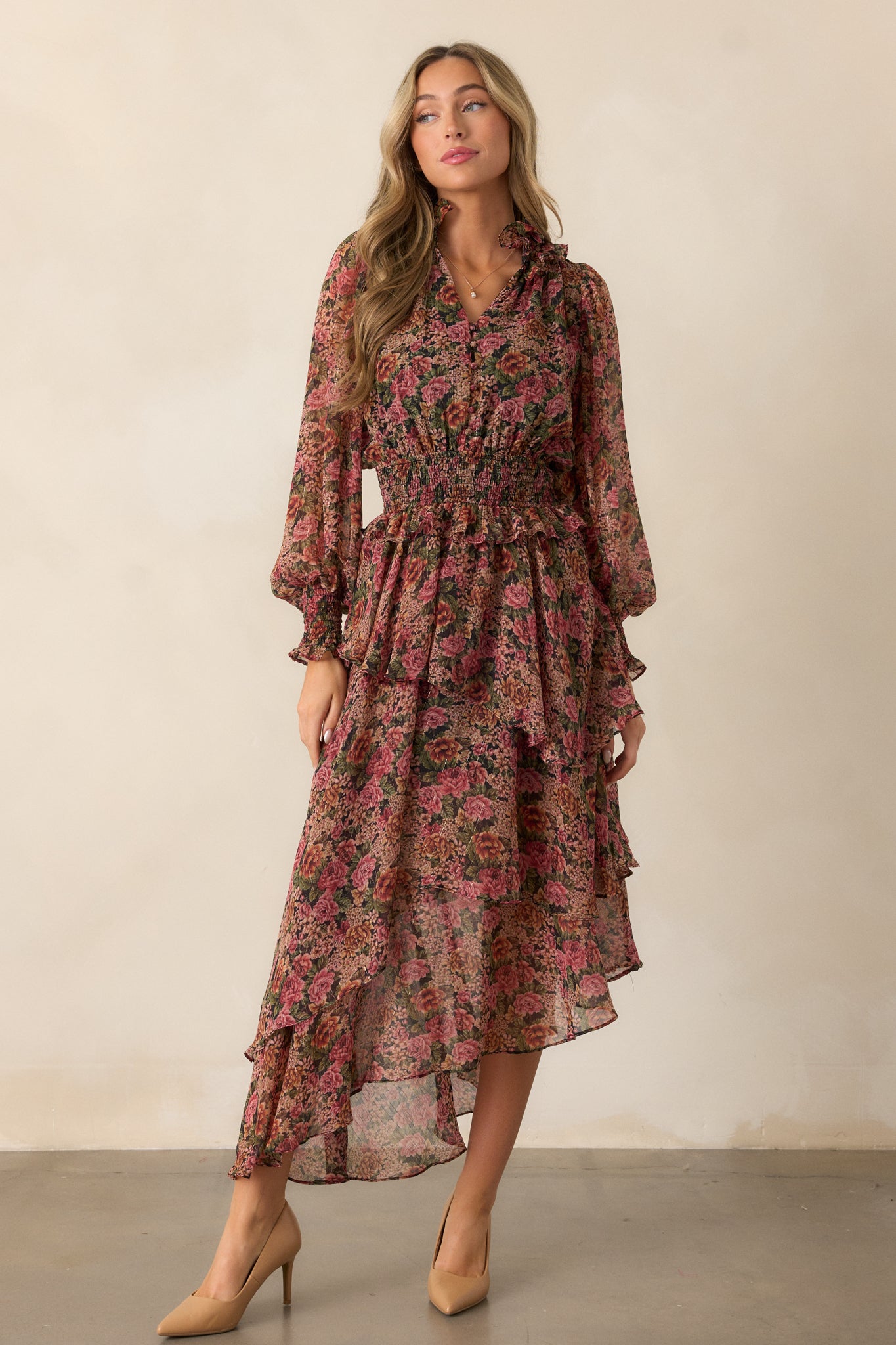 Front view highlighting the long sleeves with smocked wrist cuffs and the cascading movement of the ruffled skirt.