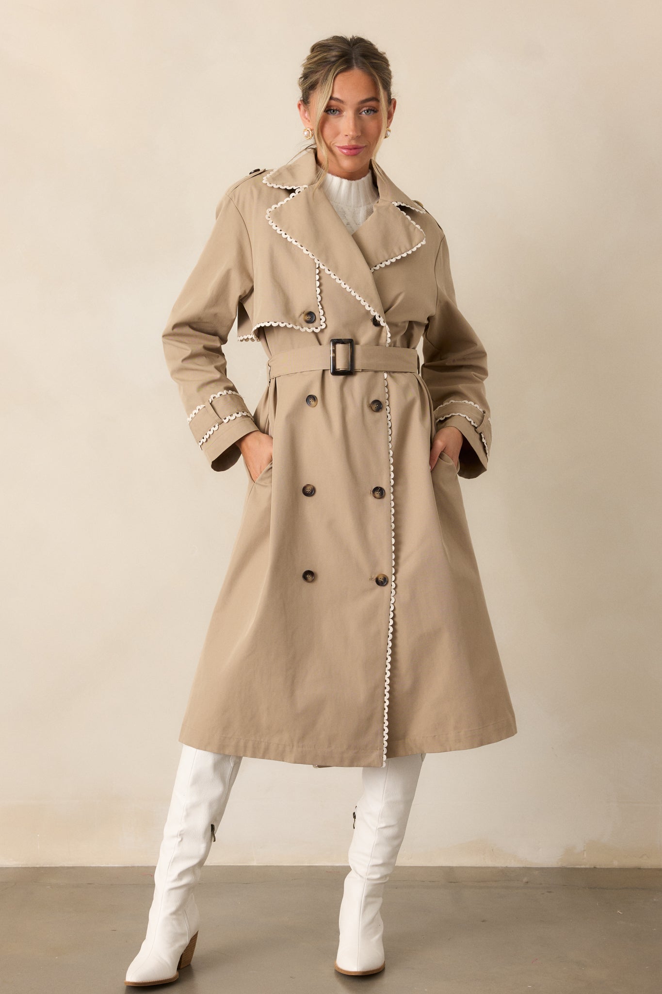 The taupe trench coat styled fully buttoned, highlighting the eight-button detailing and structured silhouette.