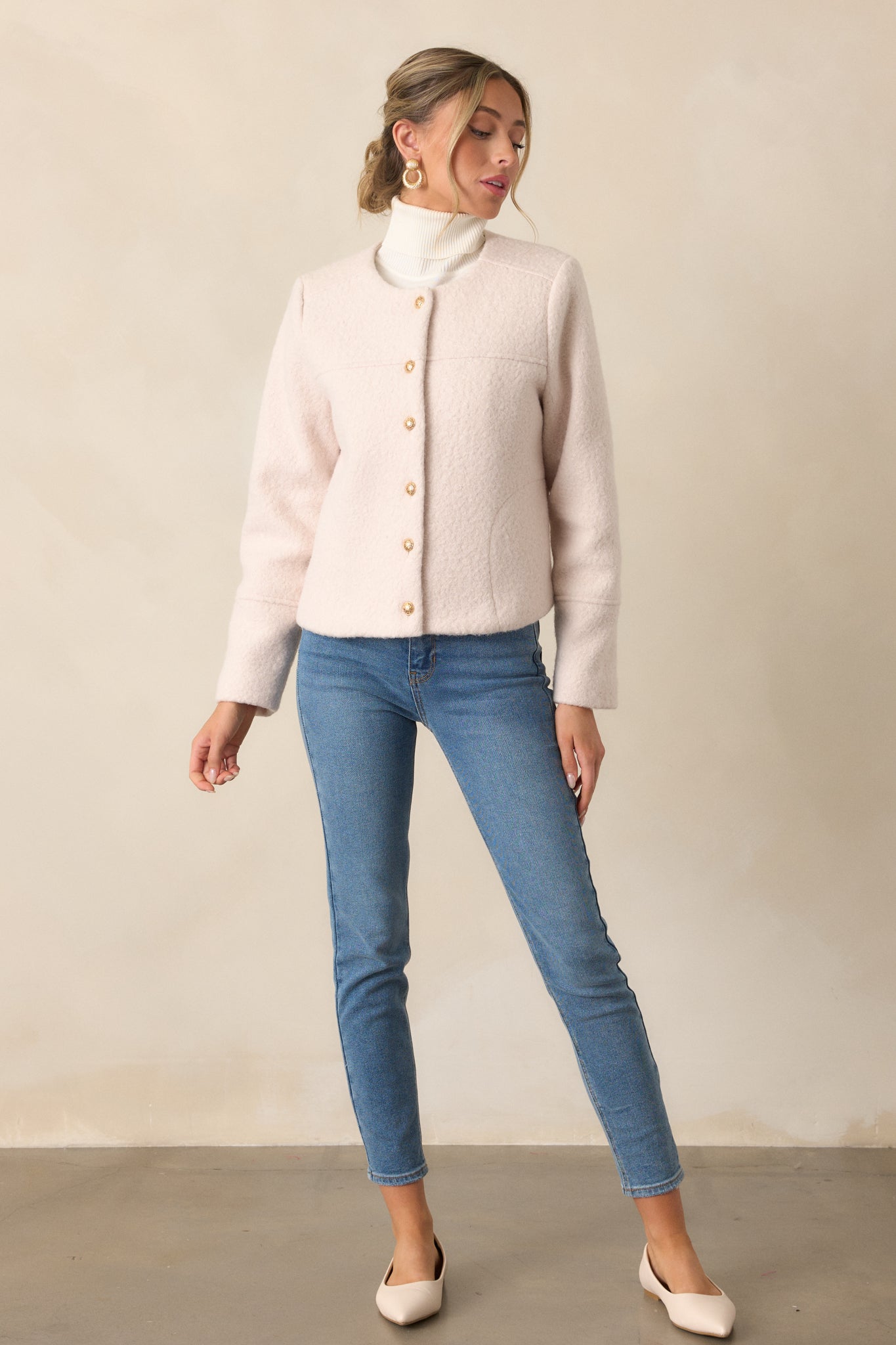 Full-length view of the ivory jacket emphasizing the structured fit and button detailing.