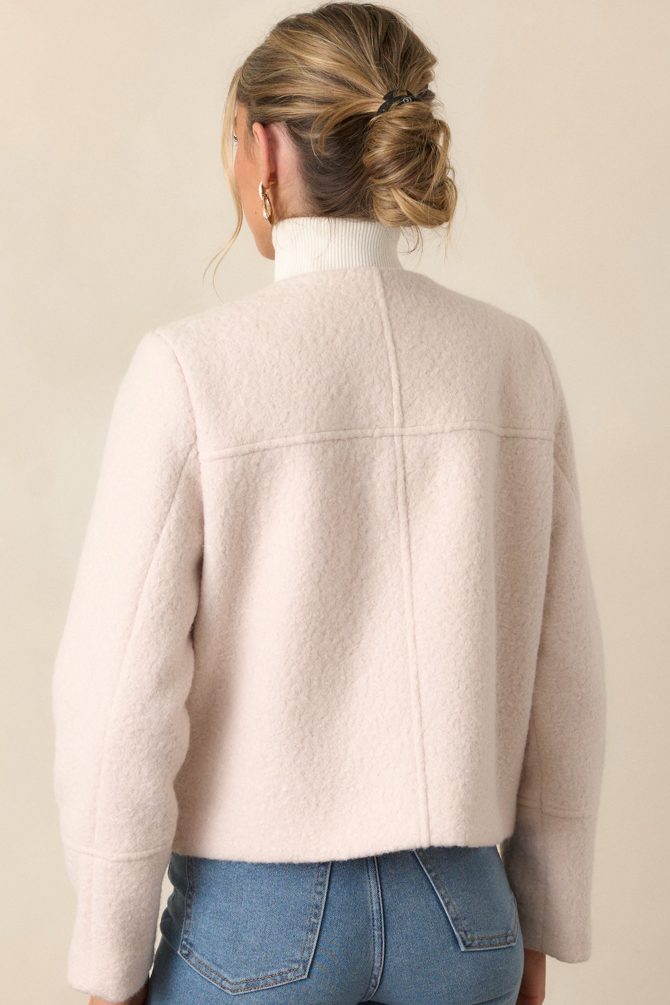 Full back view of the ivory jacket, highlighting the smooth structured fit and long sleeves.