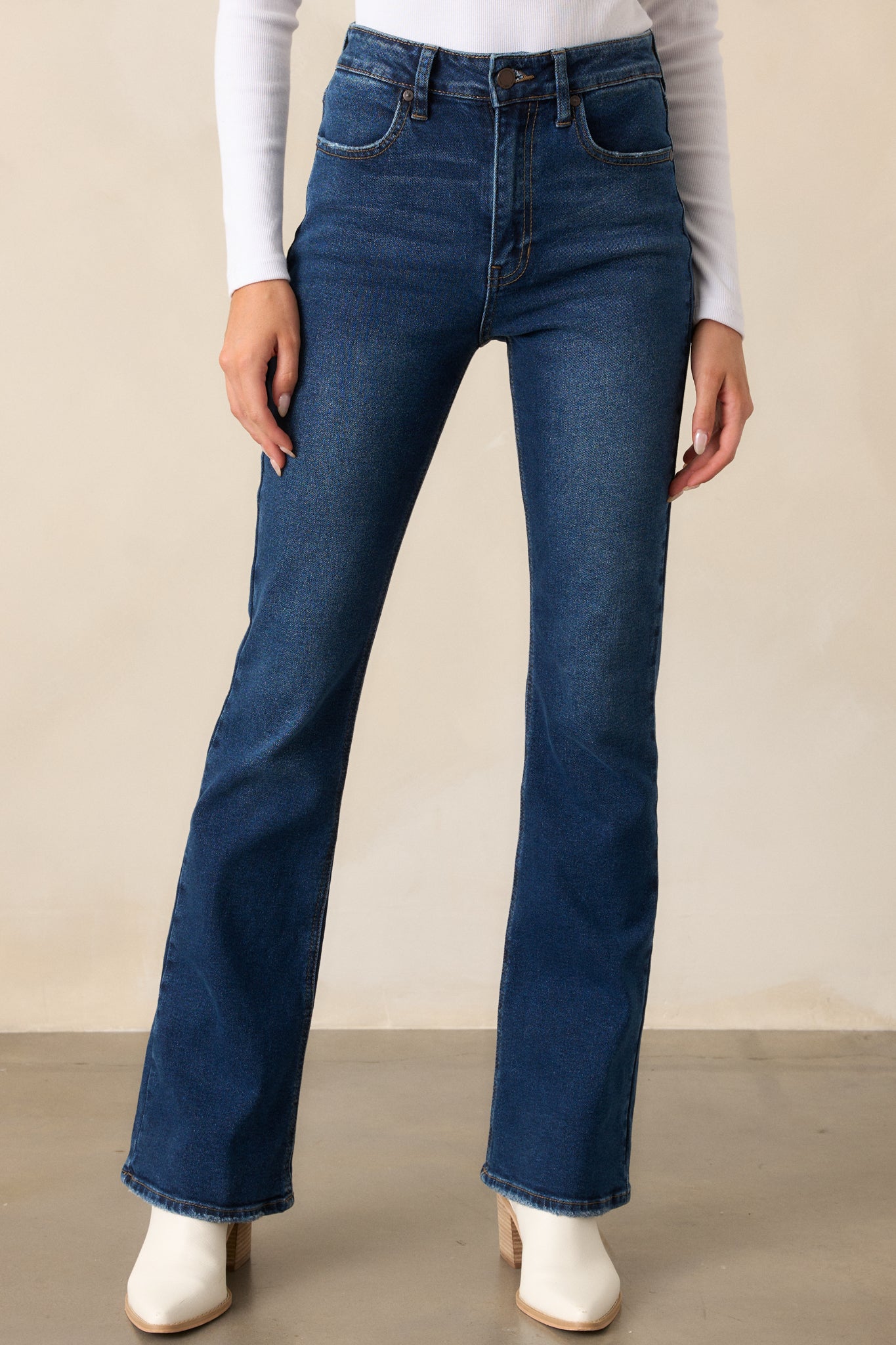 A cropped view focusing on the zipper and button closure, belt loops, and the fitted high-waisted design of the jeans.