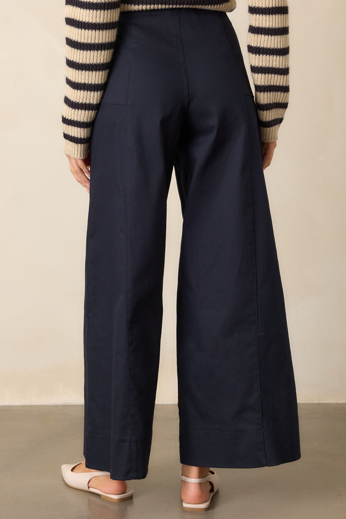 Back view of the navy pants, showing the wide-leg silhouette and high-waisted fit. 