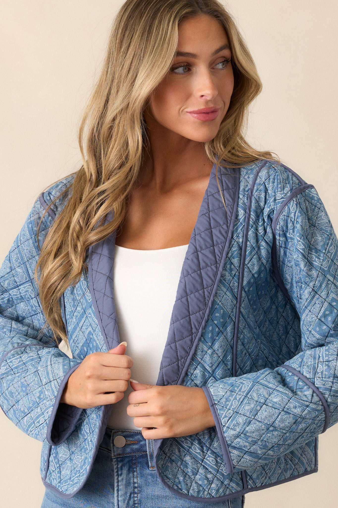 Focus on the long sleeve of the light blue jacket, showcasing the quilted pattern and navy trim detail. The geometric paisley print is partially visible on the sleeve.