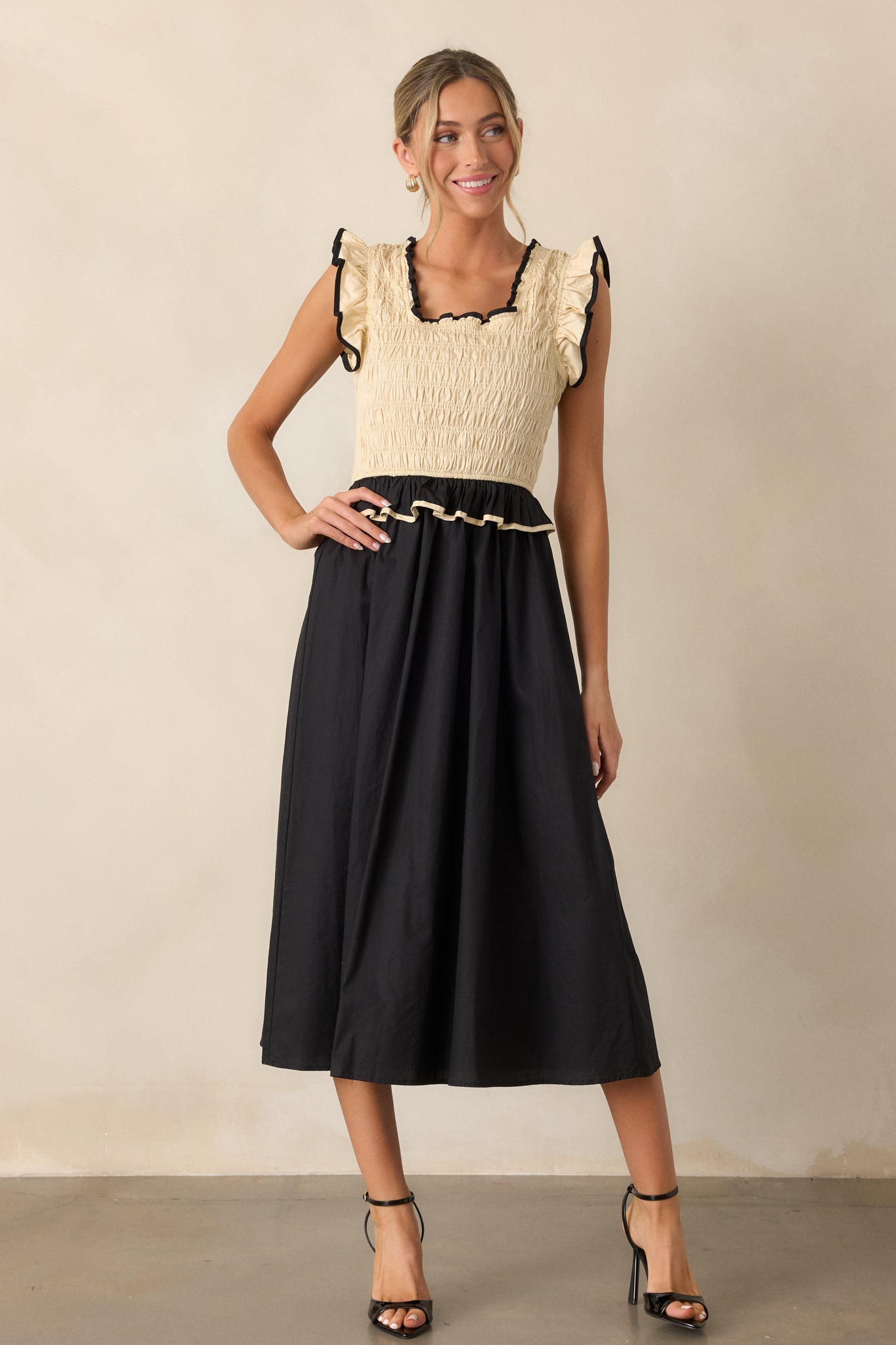 A full view of the dress highlighting the fitted smocked texture and the striking contrast of the ivory and black pattern.