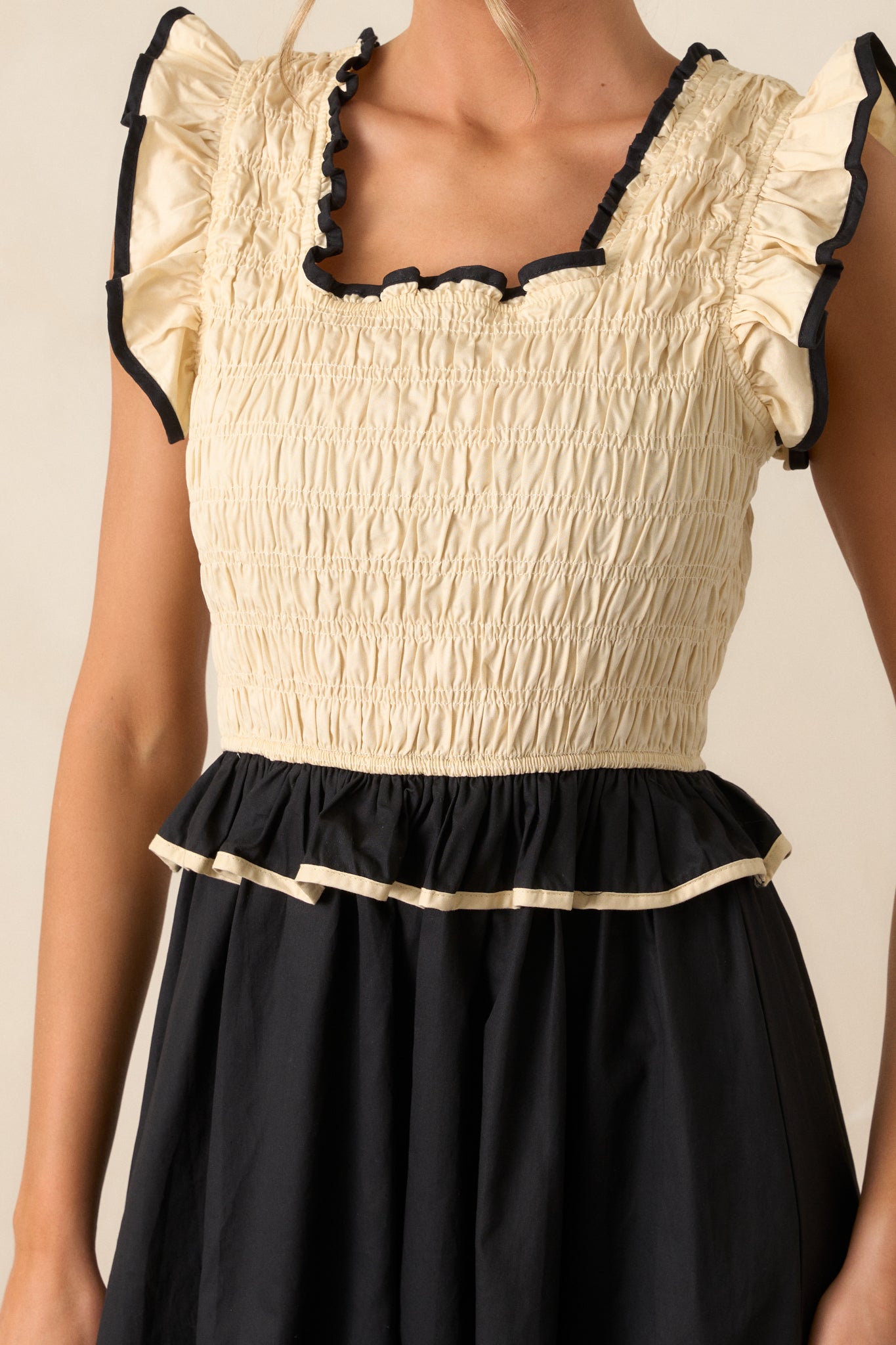 A close-up of the dress's smocked top, showing the intricate texture and the alternating ivory and black design in detail.