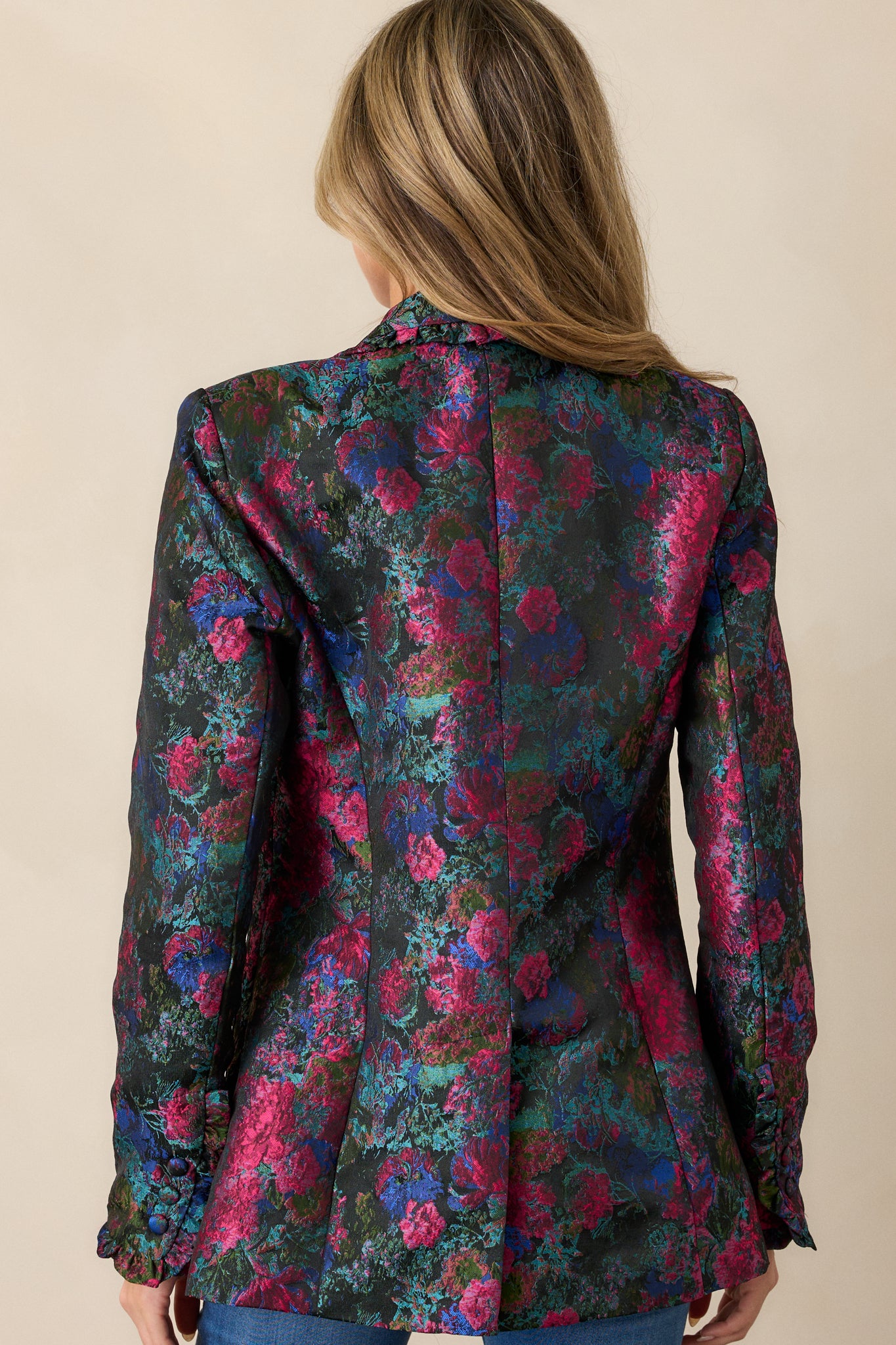 Back view of the blazer, showing the full floral pattern across the back and the continuous ruffle trim along the back edges and hem.