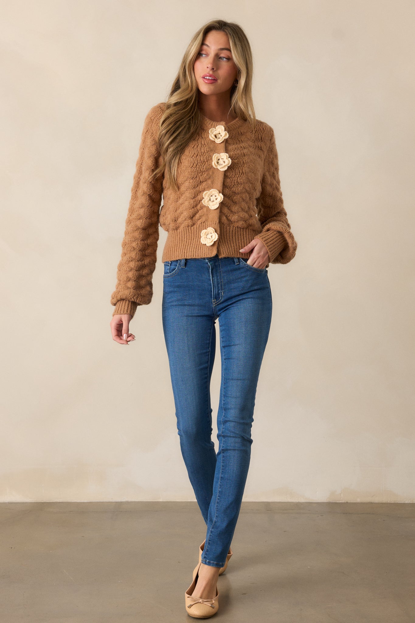 Another front view of the honey cardigan, highlighting the ribbed knit hem and functional snap buttons with knit flower details.