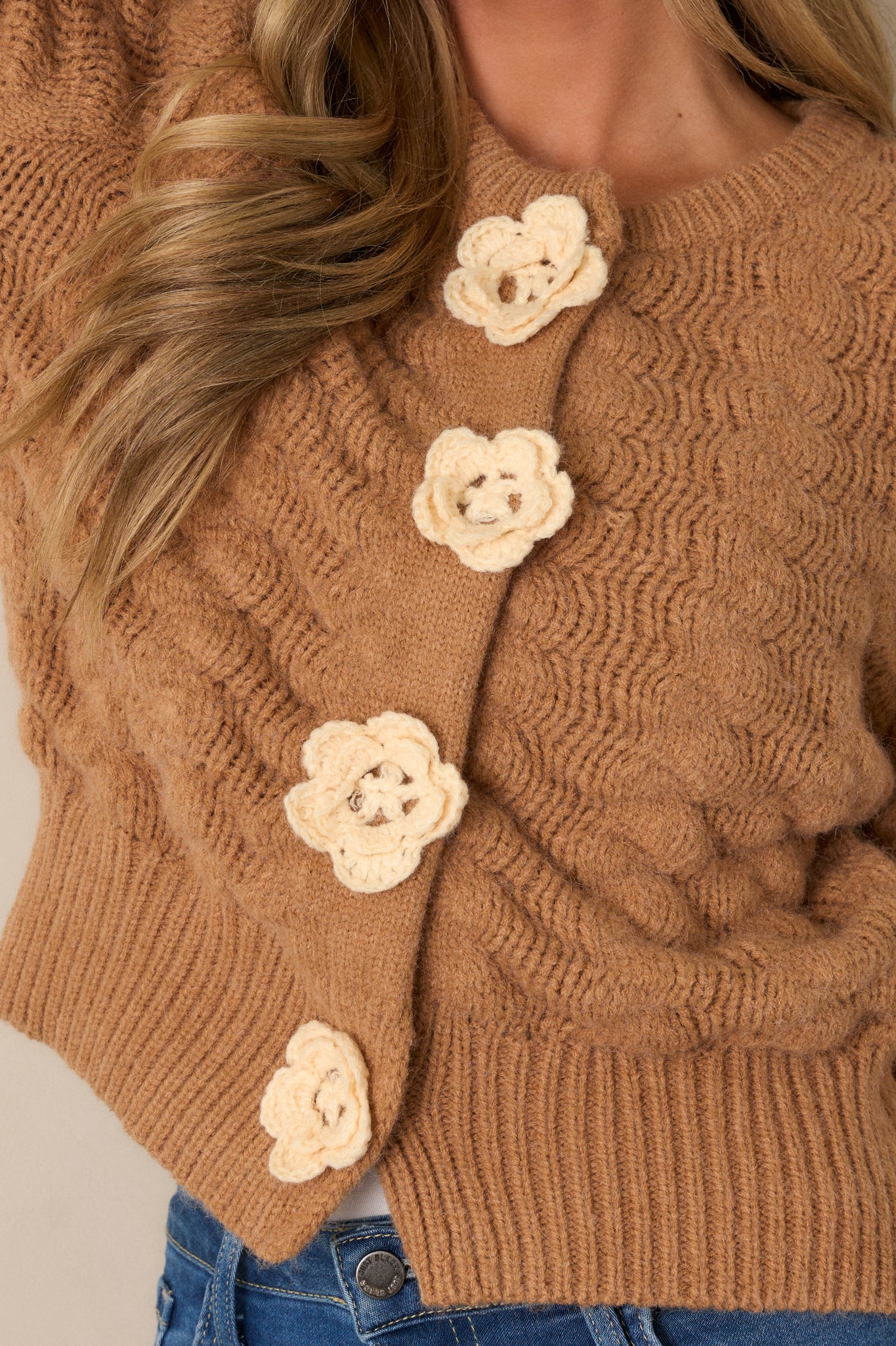 A close-up shot of the four knit flower functional snap buttons, capturing the unique design and texture of the knit detailing.