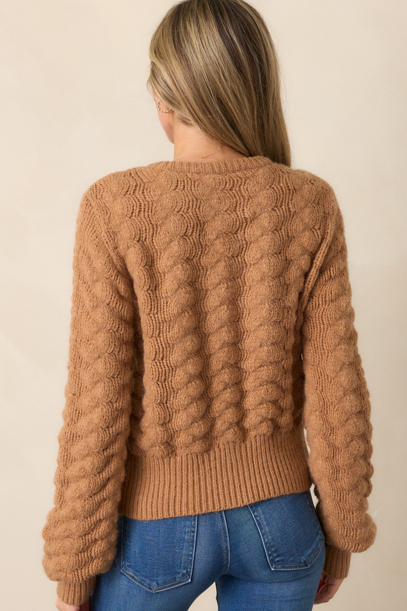 A back view of the honey cardigan, showing the clean lines, the ribbed hem, and the long sleeves with ribbed cuffs.