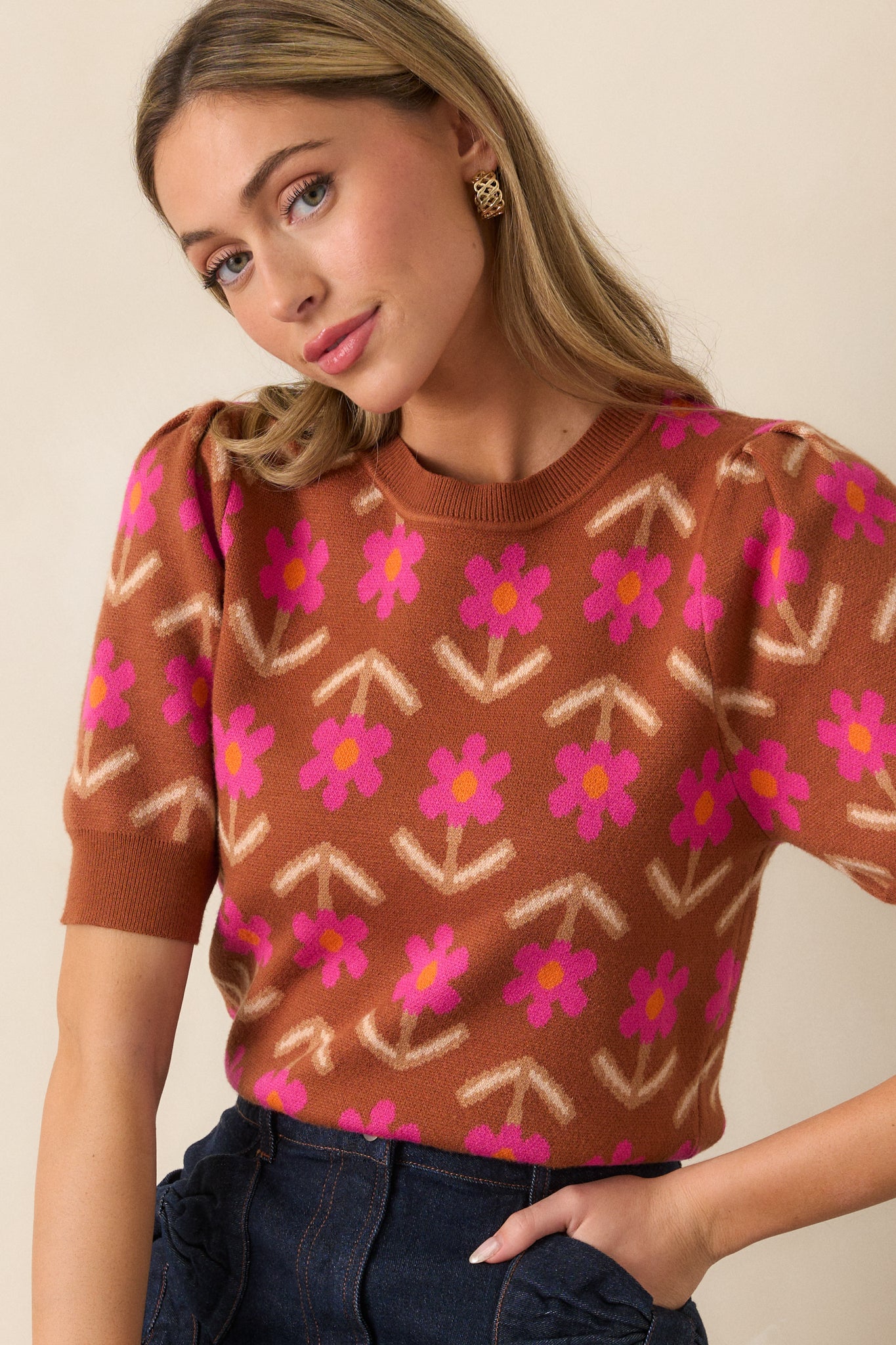 Close-up of the cinnamon sweater’s rounded neckline and geometric floral design, showing the texture of the ribbed knit hem.