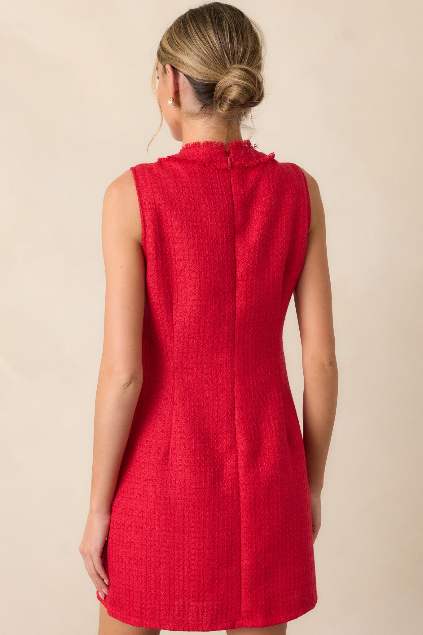 A back view of the red mini dress, highlighting the discrete back zipper and showcasing the overall clean design of the dress.