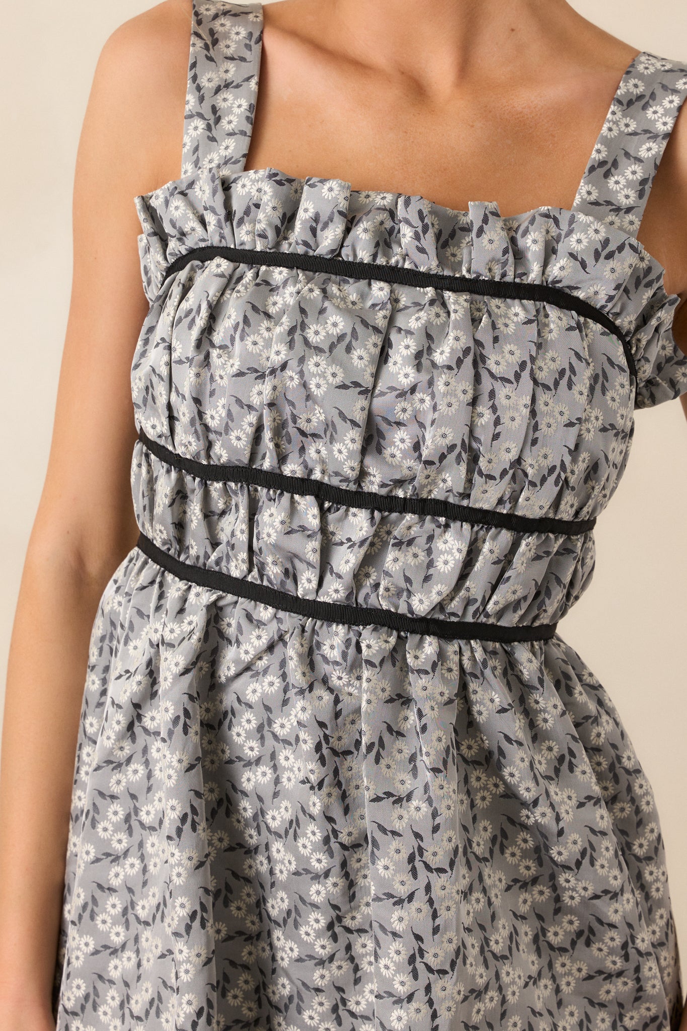 Close-up of the ruched square neckline on the grey midi dress, showcasing the texture and detailing of the black contrast trim and the self-tie bows.