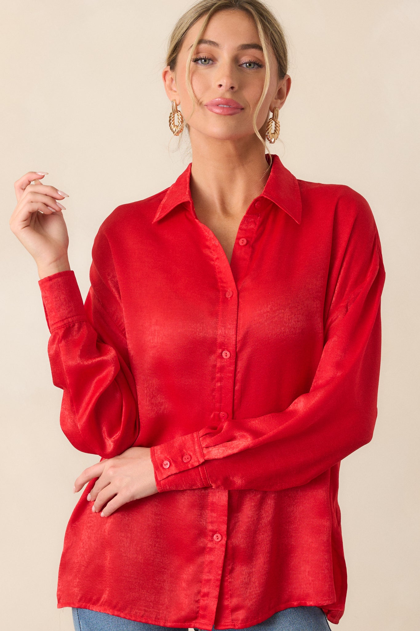 Cropped photo of the cuffed sleeves of the red top, showing the button details at the wrist and the smooth, relaxed fit of the fabric.