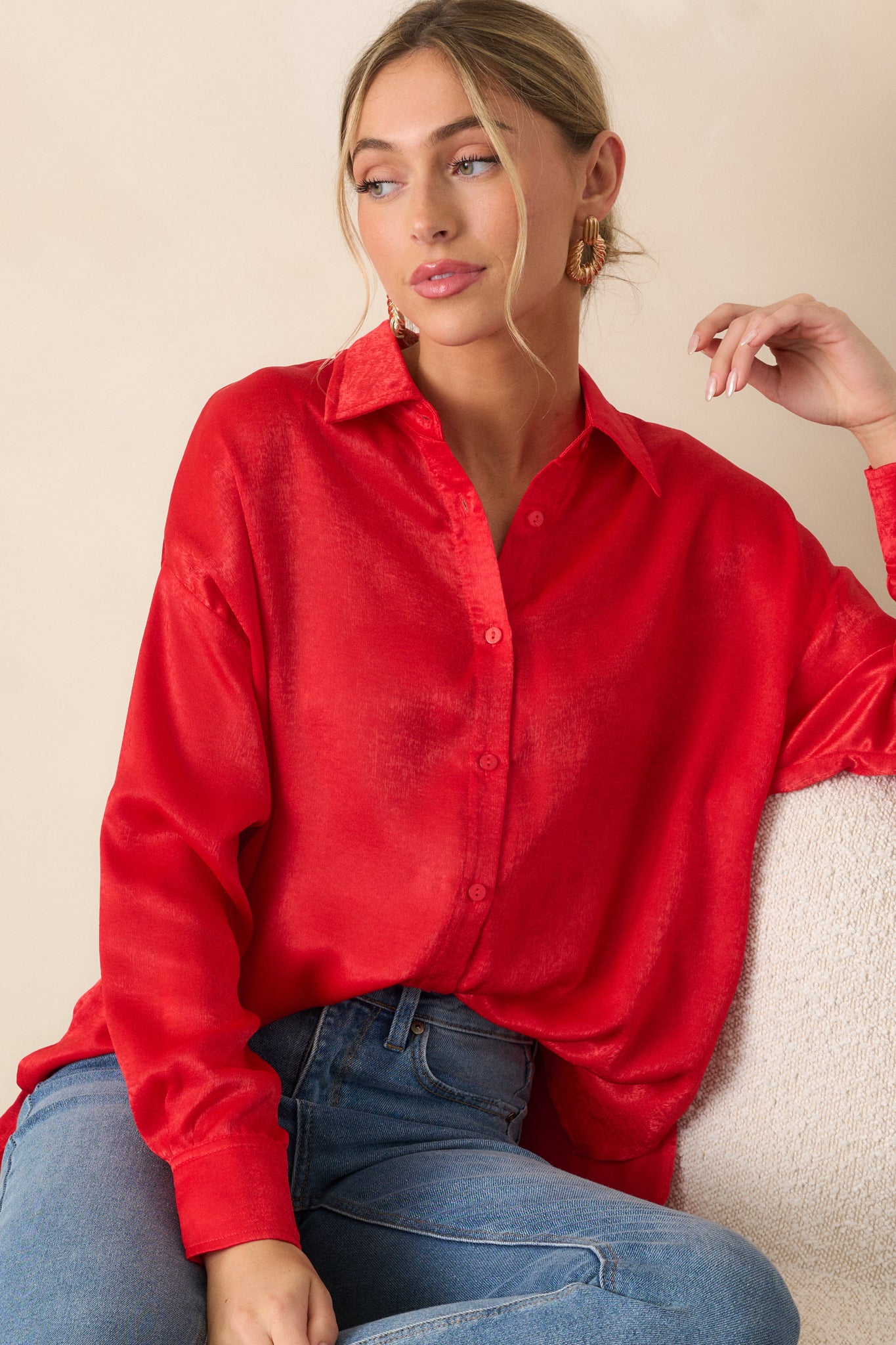 A cropped shot of the button-down front of the red top, showing the collared neckline and buttons down the center. The relaxed fit is visible as the fabric slightly drapes.