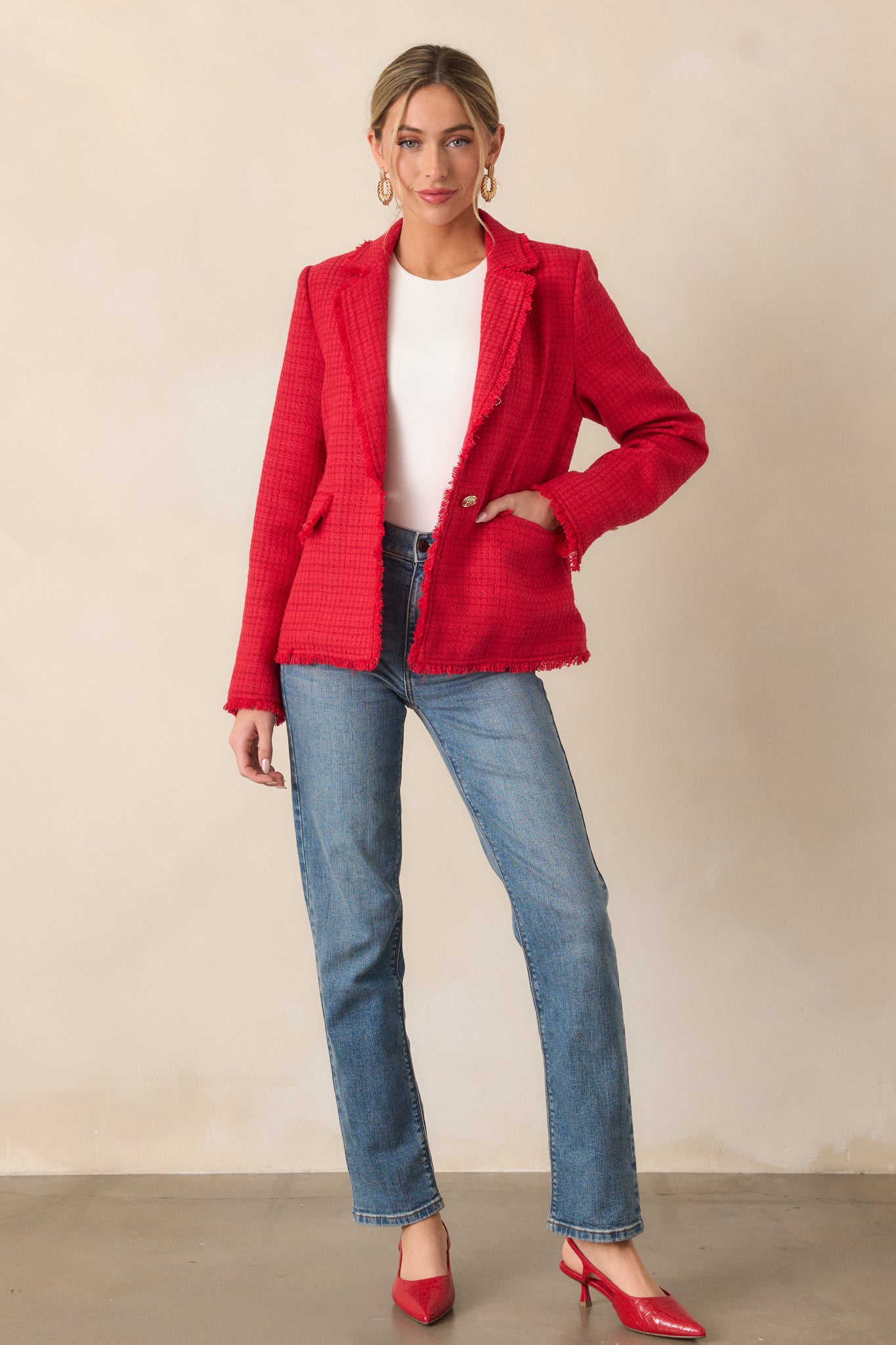 A front view of the red blazer, capturing the tweed texture and raw fringe hems along the sleeves and jacket hem.