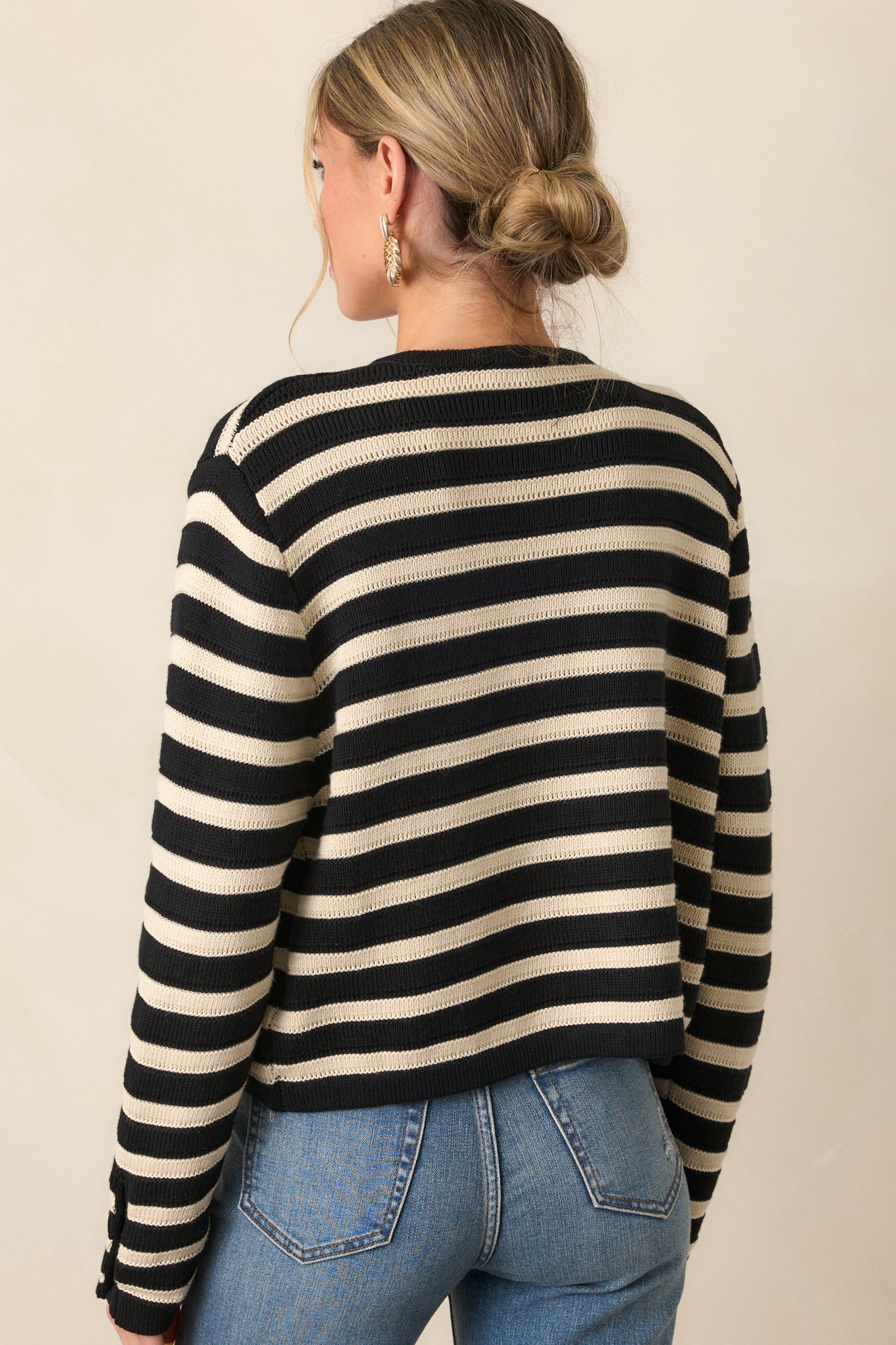 Back view of the cardigan, showing the continuation of the tan and black stripe pattern and the smooth finish of the back design.