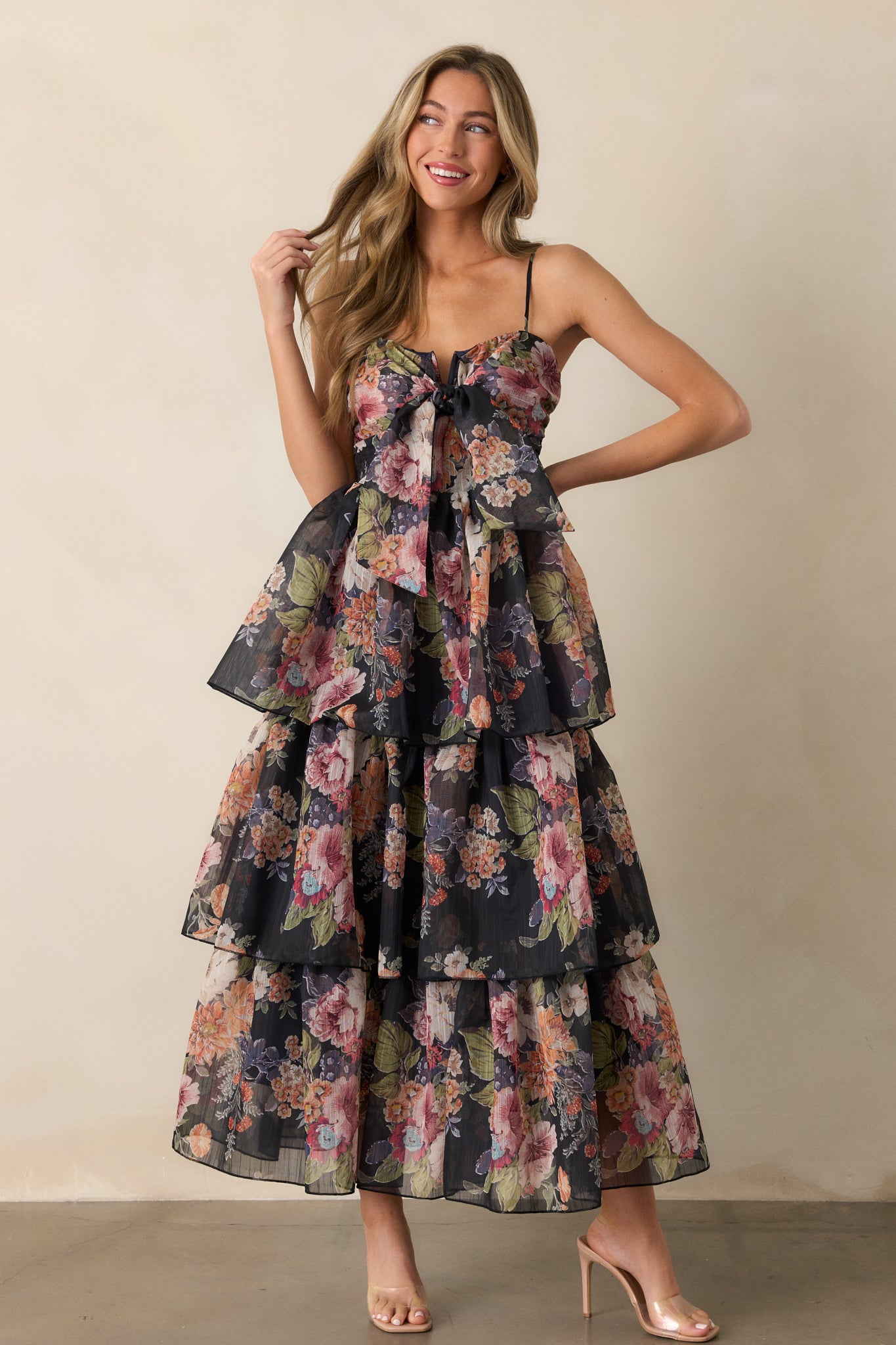 Full view of a navy dress with a notch neckline, featuring a self-tie accent, a beautiful floral design, and a tiered skirt for a flowing silhouette.