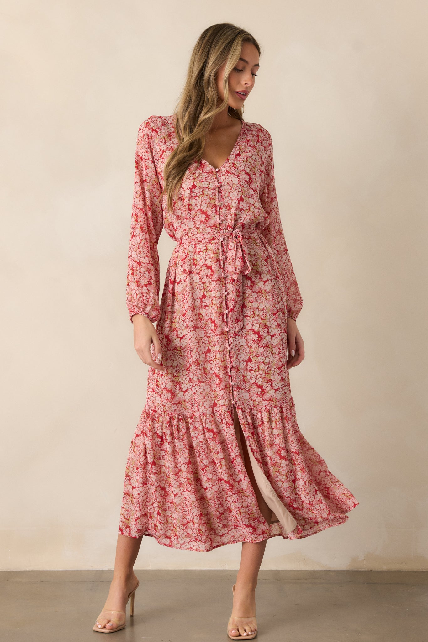 Angled front view of the cranberry dress, emphasizing the v-neck design, button front, and the tiered skirt, with the floral print adding texture and dimension.