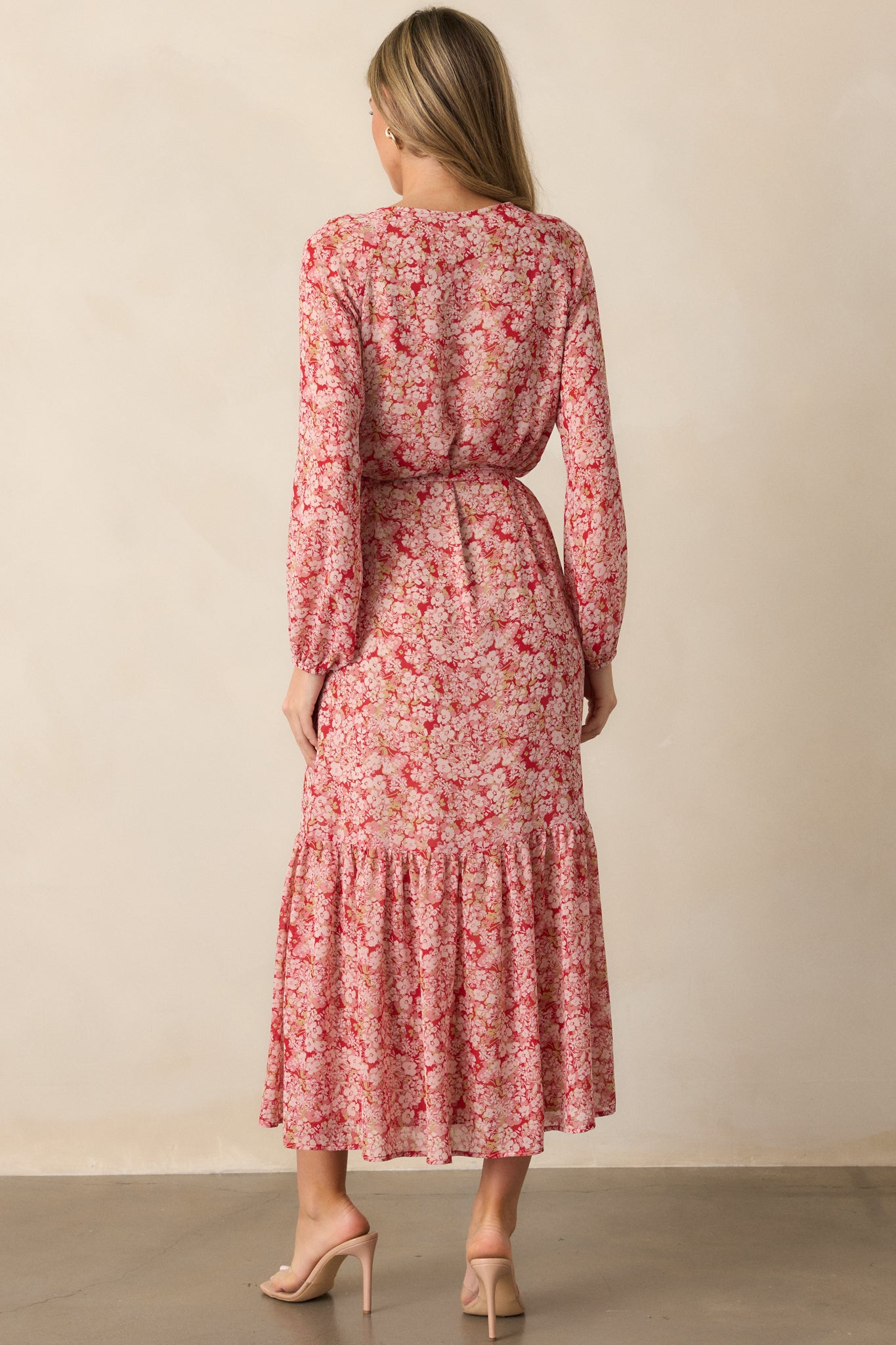 Back view of the cranberry dress, showing the flow of the tiered skirt, long sleeves, and the button front detail with the self-tie waistband visible from behind.