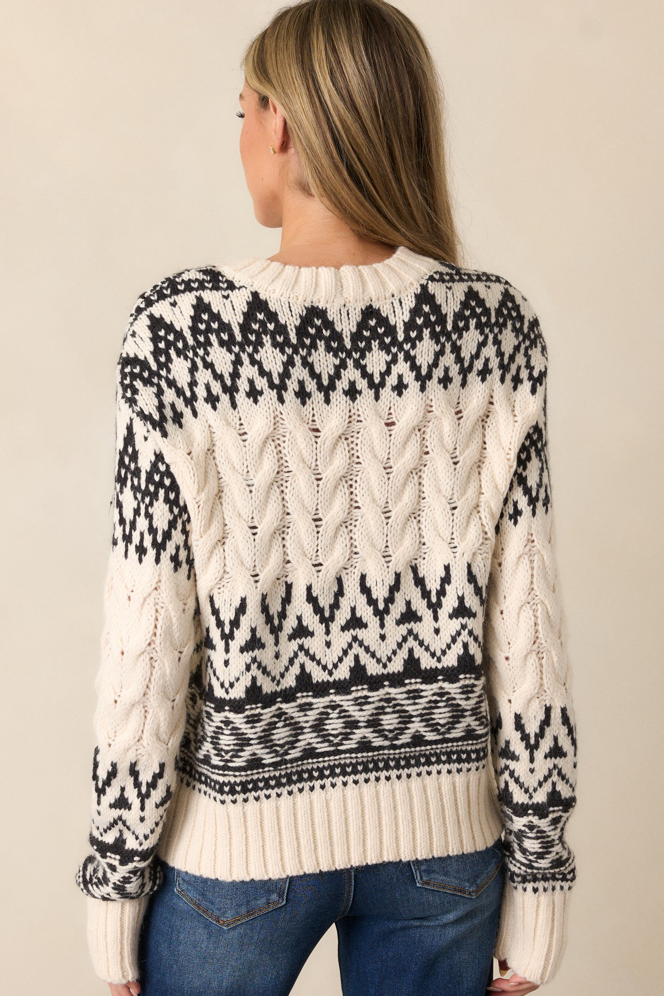 Back view of the seasalt ivory sweater, highlighting the cable knit texture, black geometric print, and smooth fit across the back.