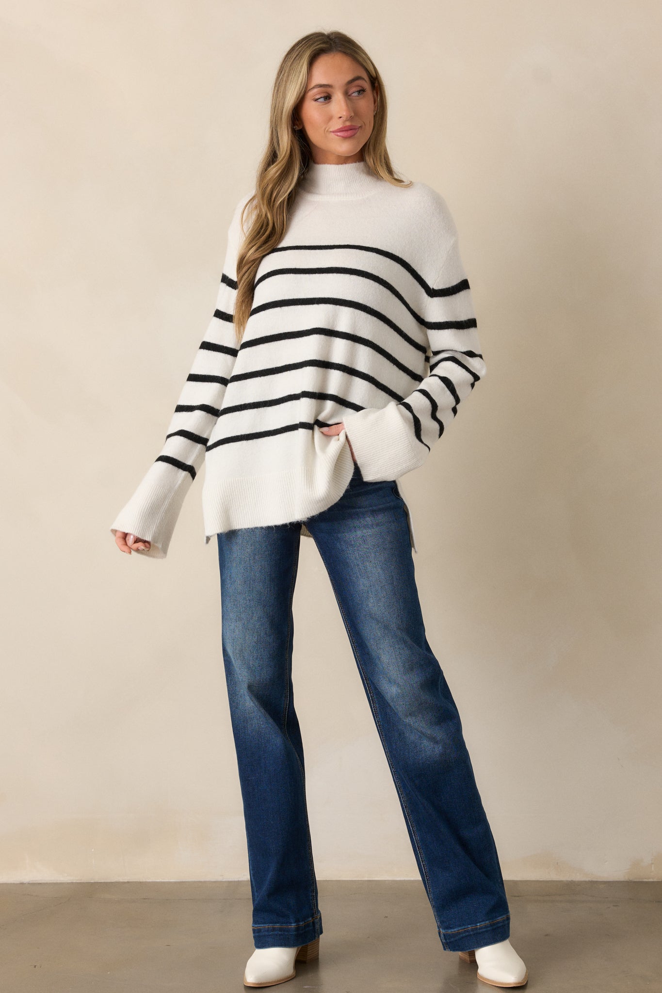 Full-body perspective highlighting the elegant stripe detailing and draped silhouette of the ivory sweater.