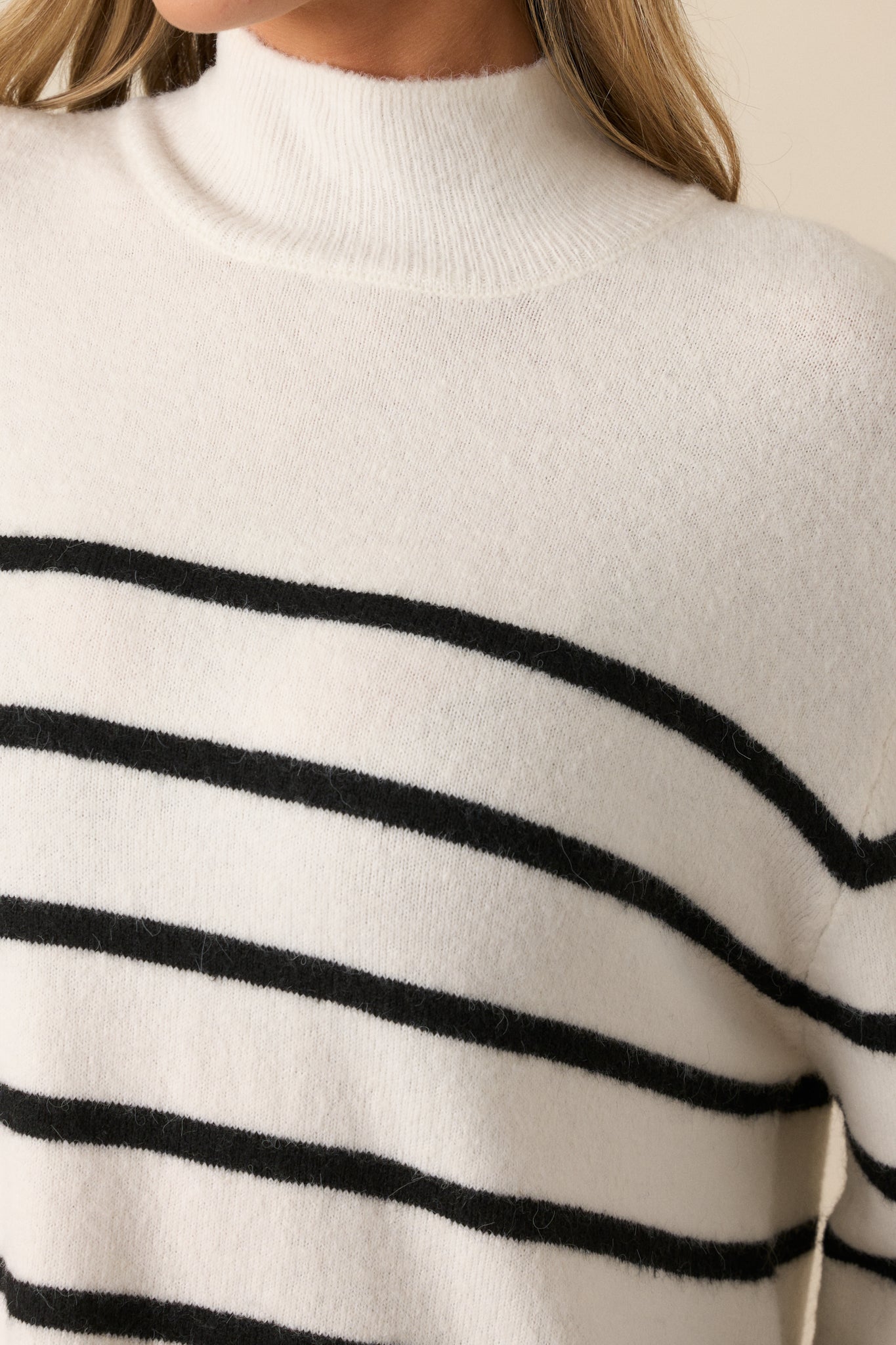 Close-up of the sweater's fabric texture, showcasing the intricate stripe pattern and rib knit finish in detail.