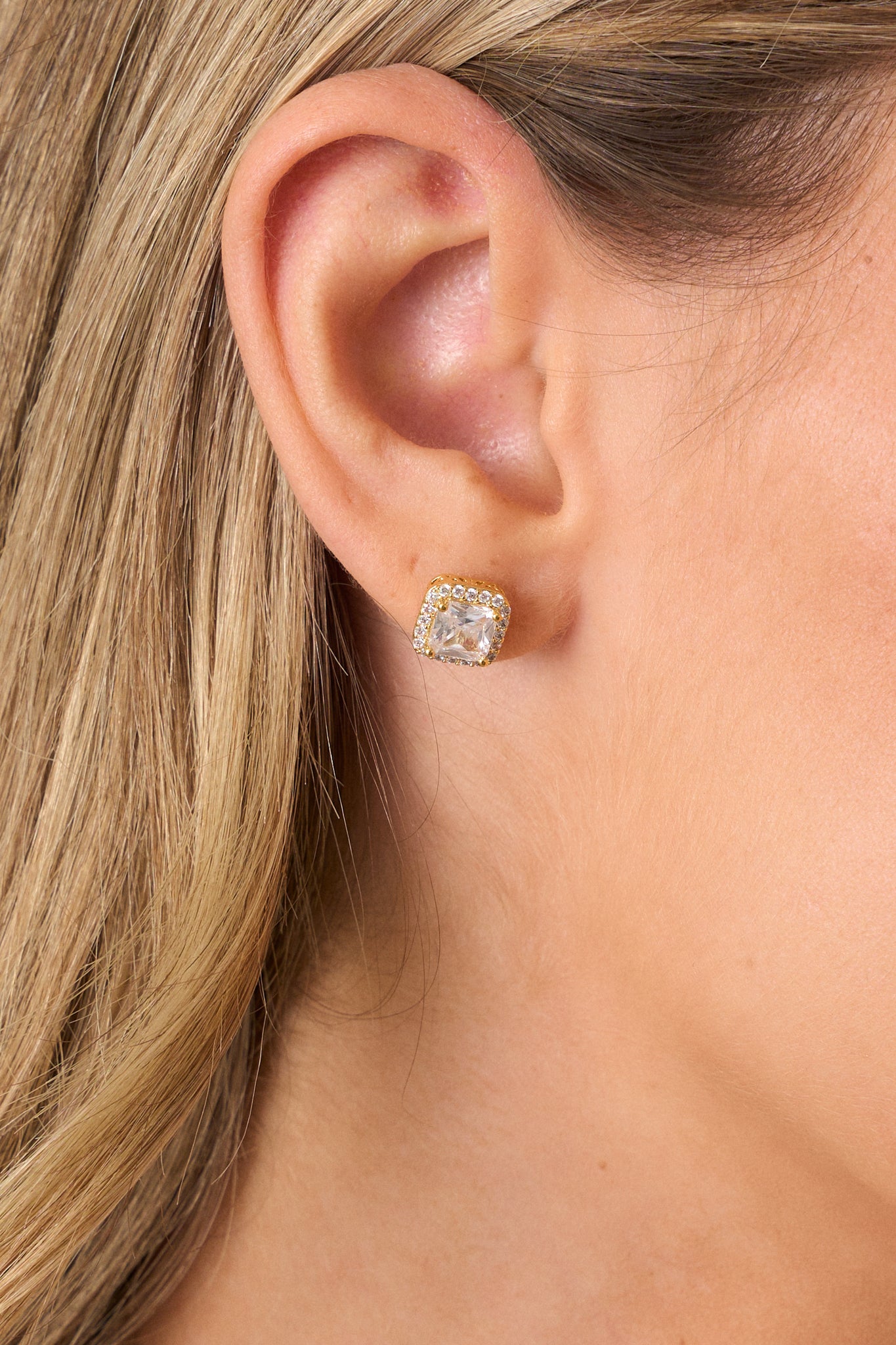 A side view of the earrings, focusing on the square shape and the gold box design under the rhinestone, highlighting the secure back postings.