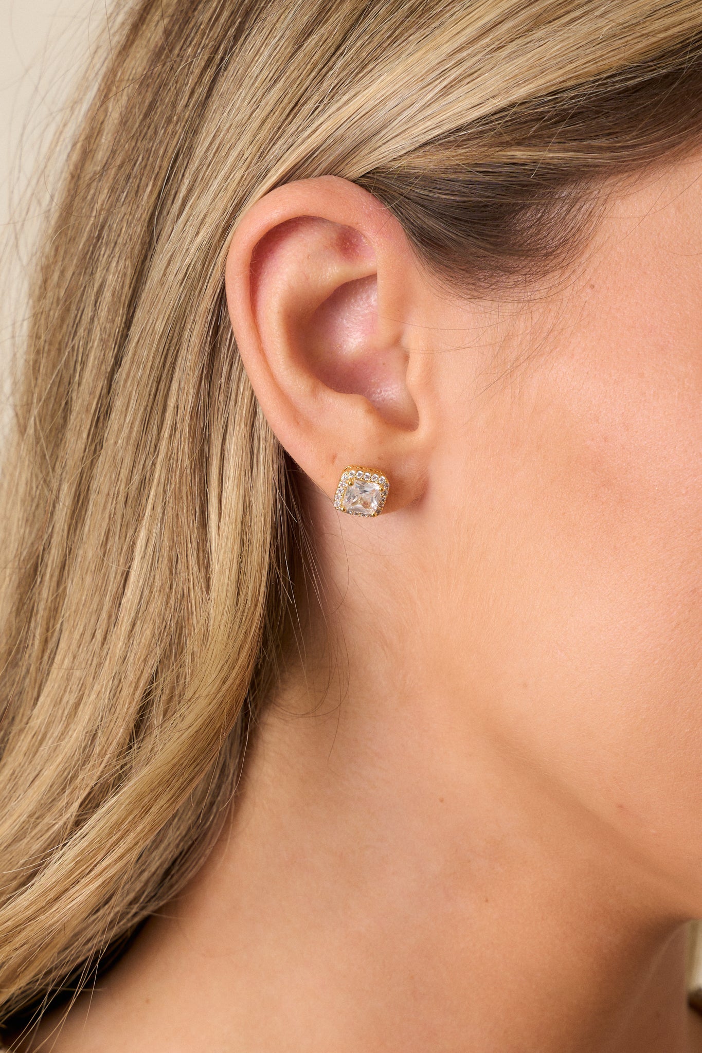 Front shot of the gold earrings showing the square shape with a large square rhinestone in the center, surrounded by a border of small rhinestones and a unique gold box design beneath the center stone.