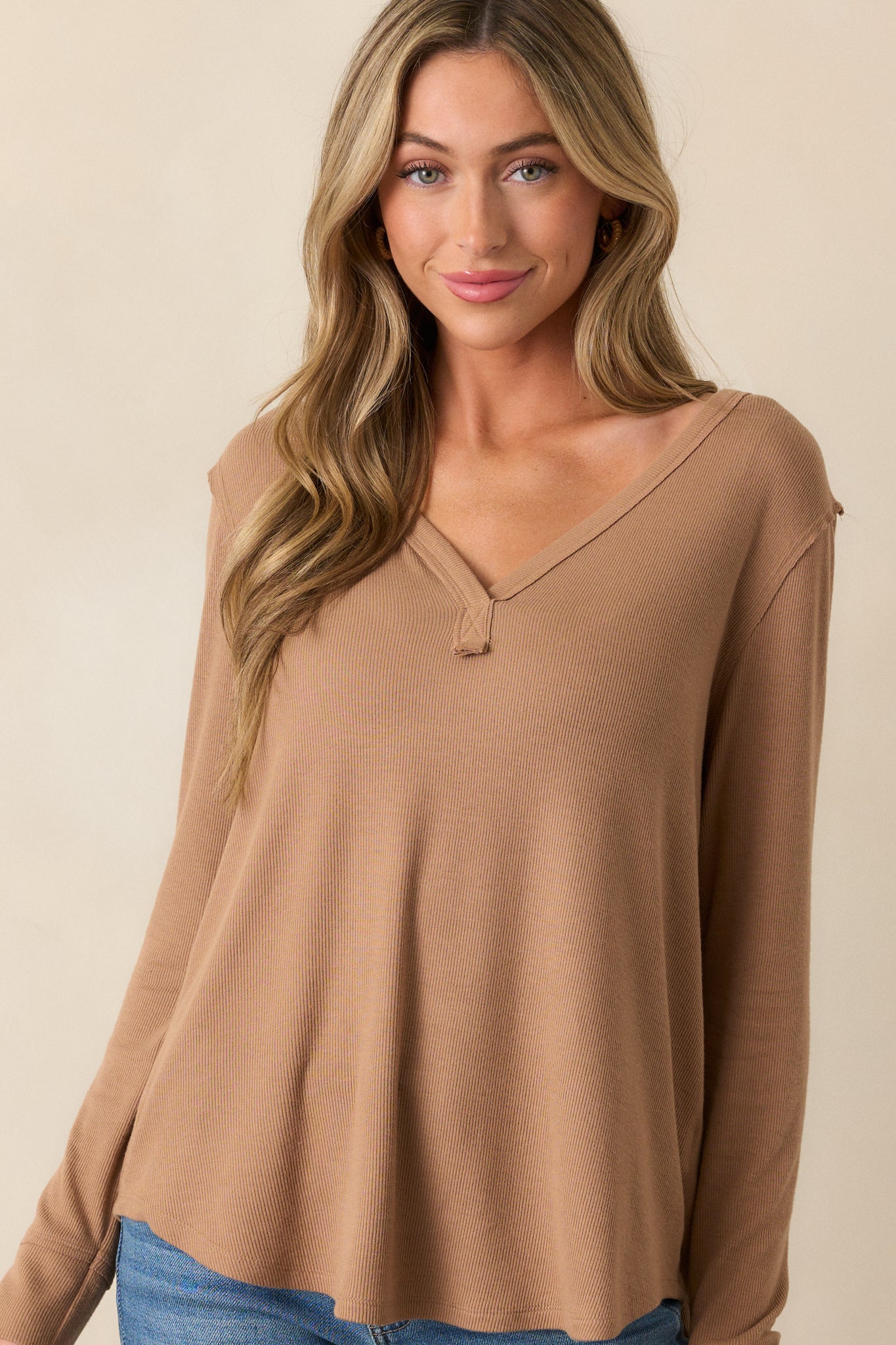 Detailed shot of the long sleeve on the tan top, showcasing the soft ribbed fabric and smooth, comfortable fit.