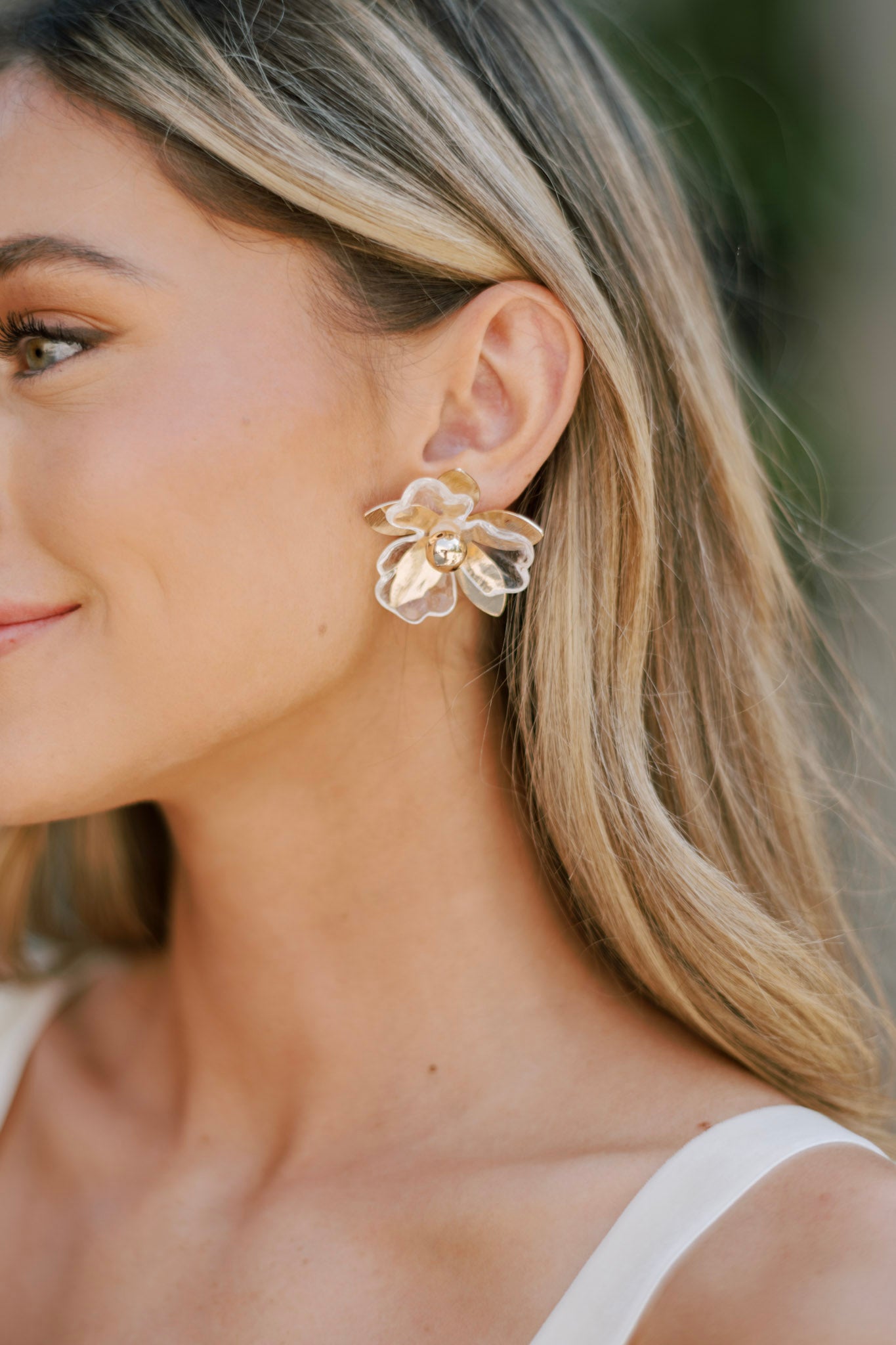 These gold flower earring feature gold & clear petals, a gold bead center, and secure post hole backings.