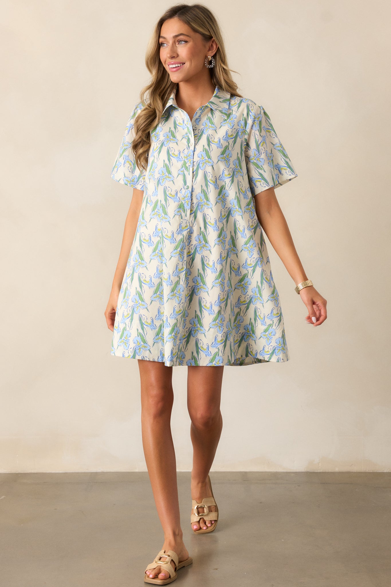 The short sleeves and detailed floral print of the blue dress are highlighted, offering a breezy, relaxed vibe.