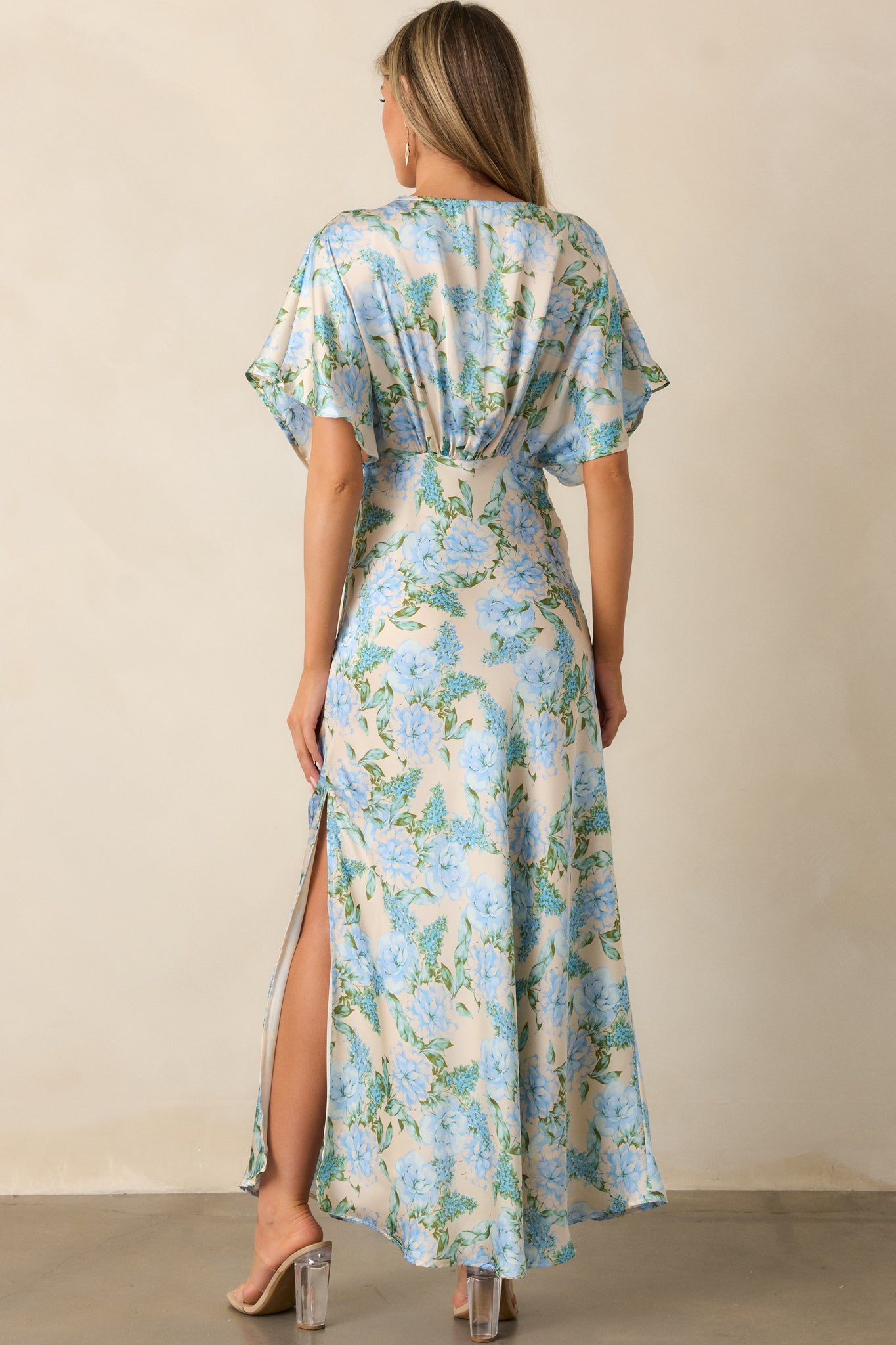 Back view of the sky blue dress displaying the smooth, uninterrupted flow of the fabric and simple, elegant design.