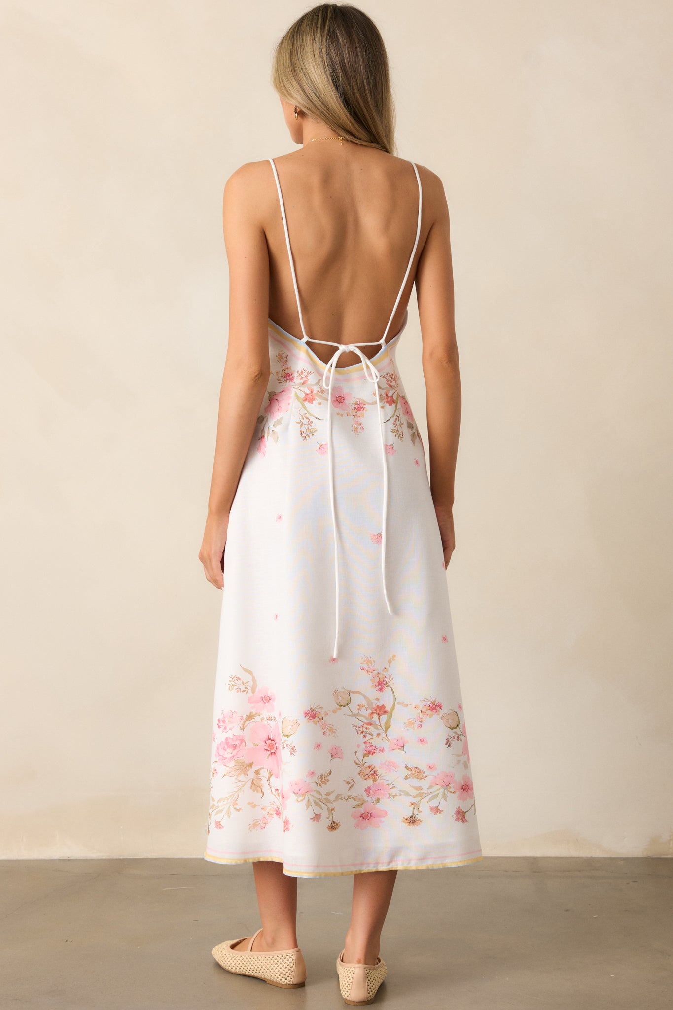 A graceful view of the floral midi dress from behind, where the open-back design and charming tie details create a picture-perfect look.