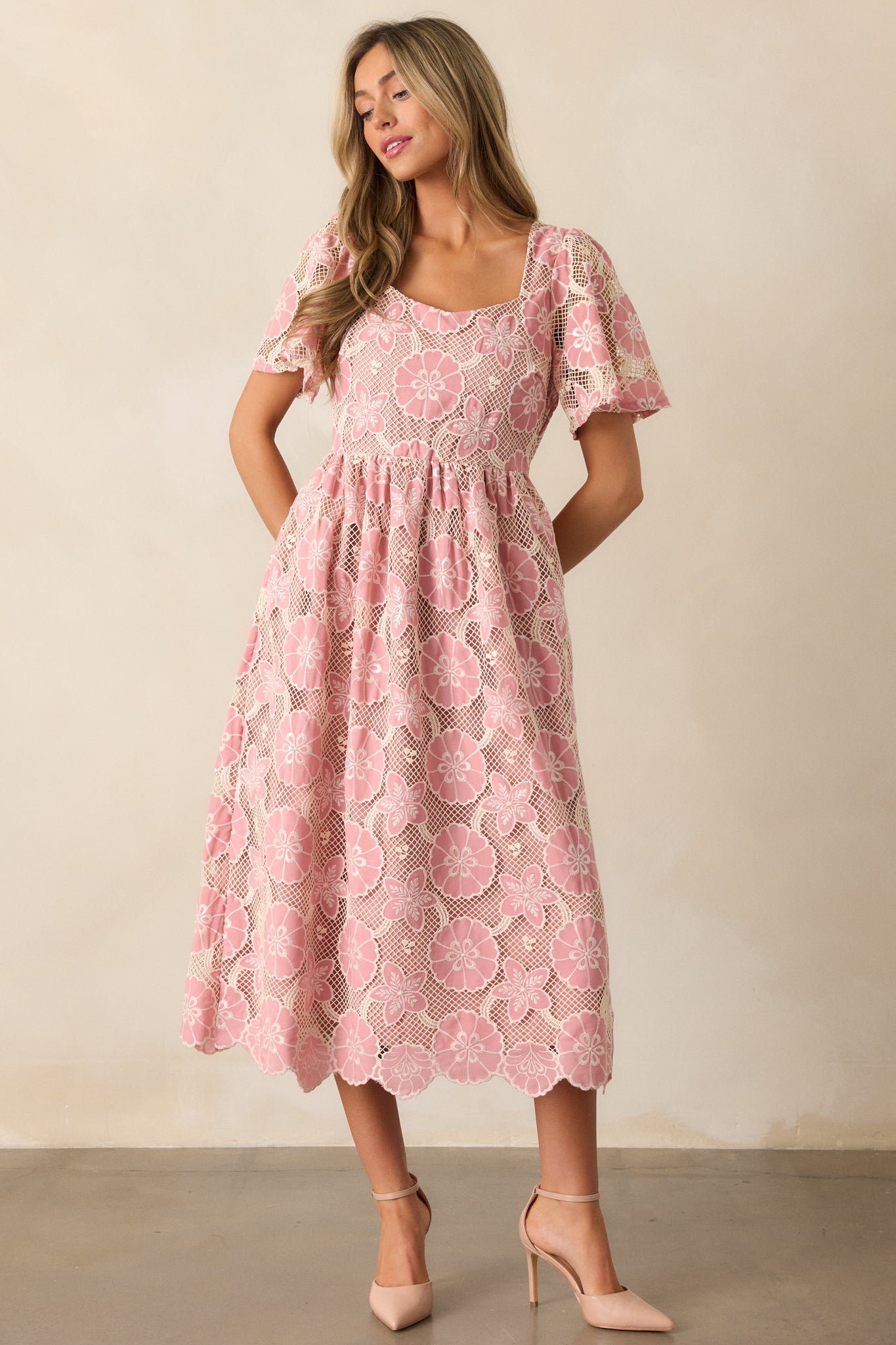 A front-facing view of the dress with an emphasis on the floral embroidery along the bust and the soft flow of the skirt, showcasing the sheer sleeves.