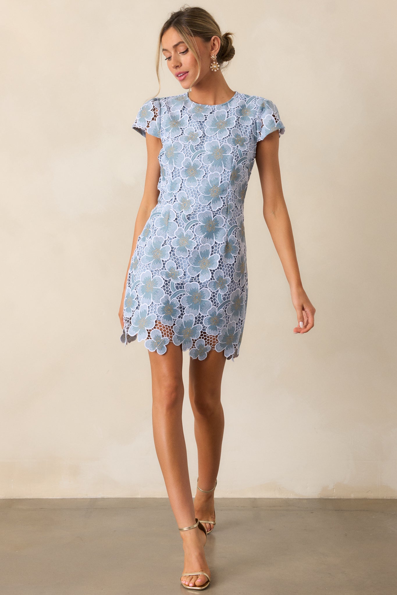 A full-length view of the sky blue mini dress, highlighting its flattering silhouette and the delicate floral embroidery along the side.