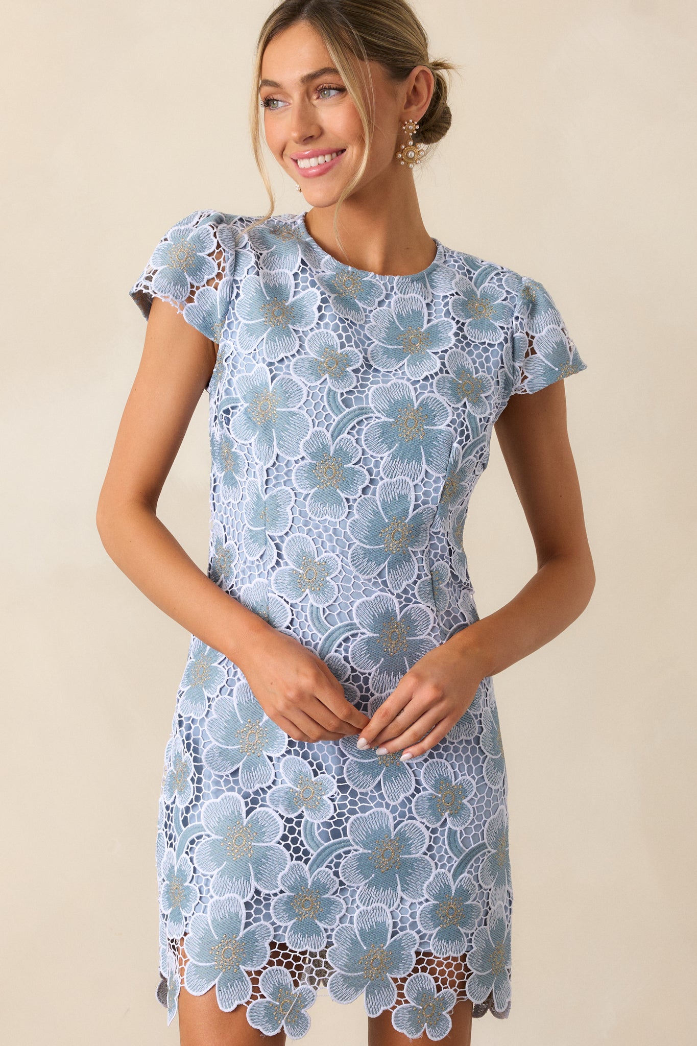 A cropped view of the neckline and cap sleeves, showcasing the intricate floral embroidery and seamless design.