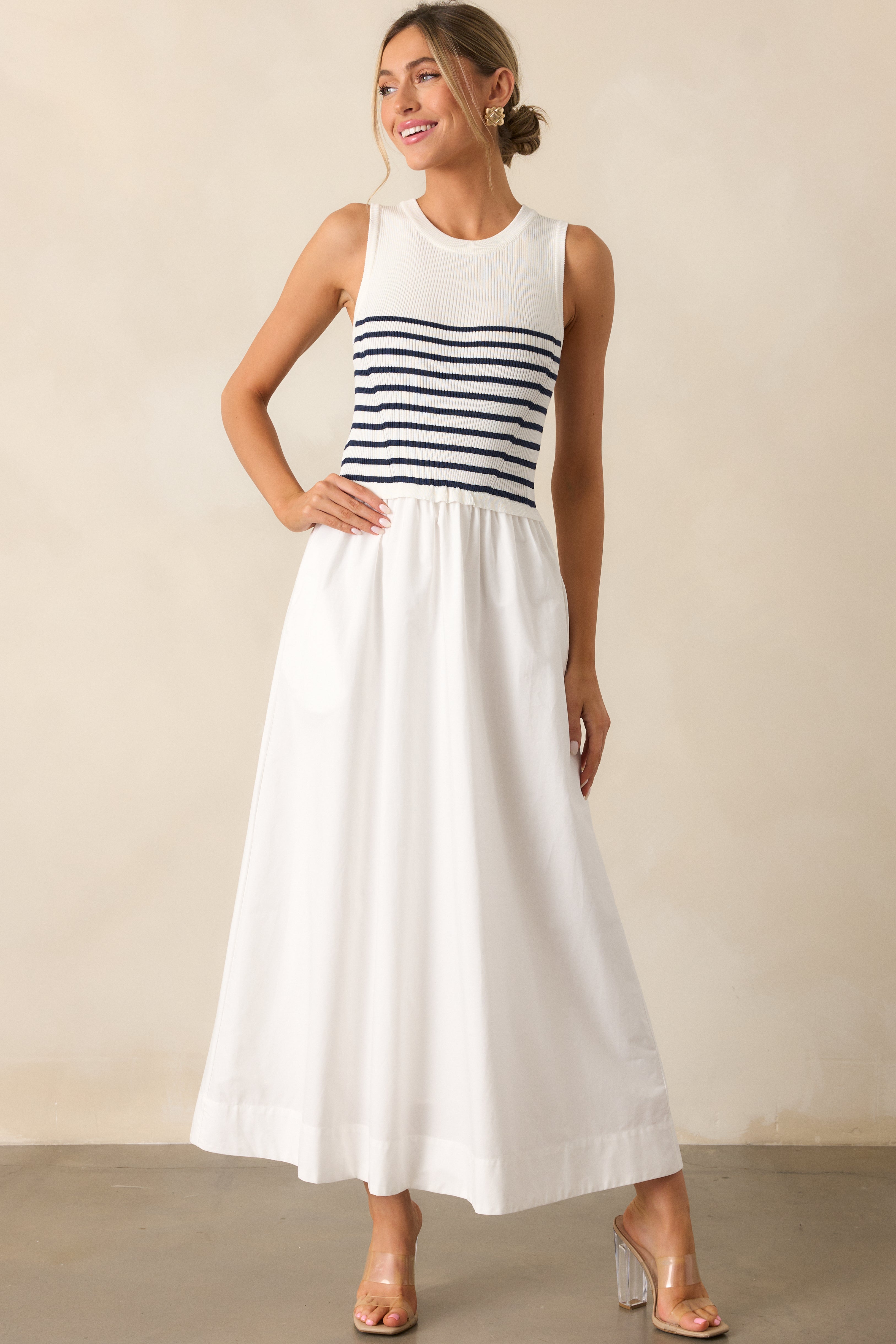 Front-facing full shot of the white stripe dress, highlighting the round neckline and fitted bodice with functional pockets.