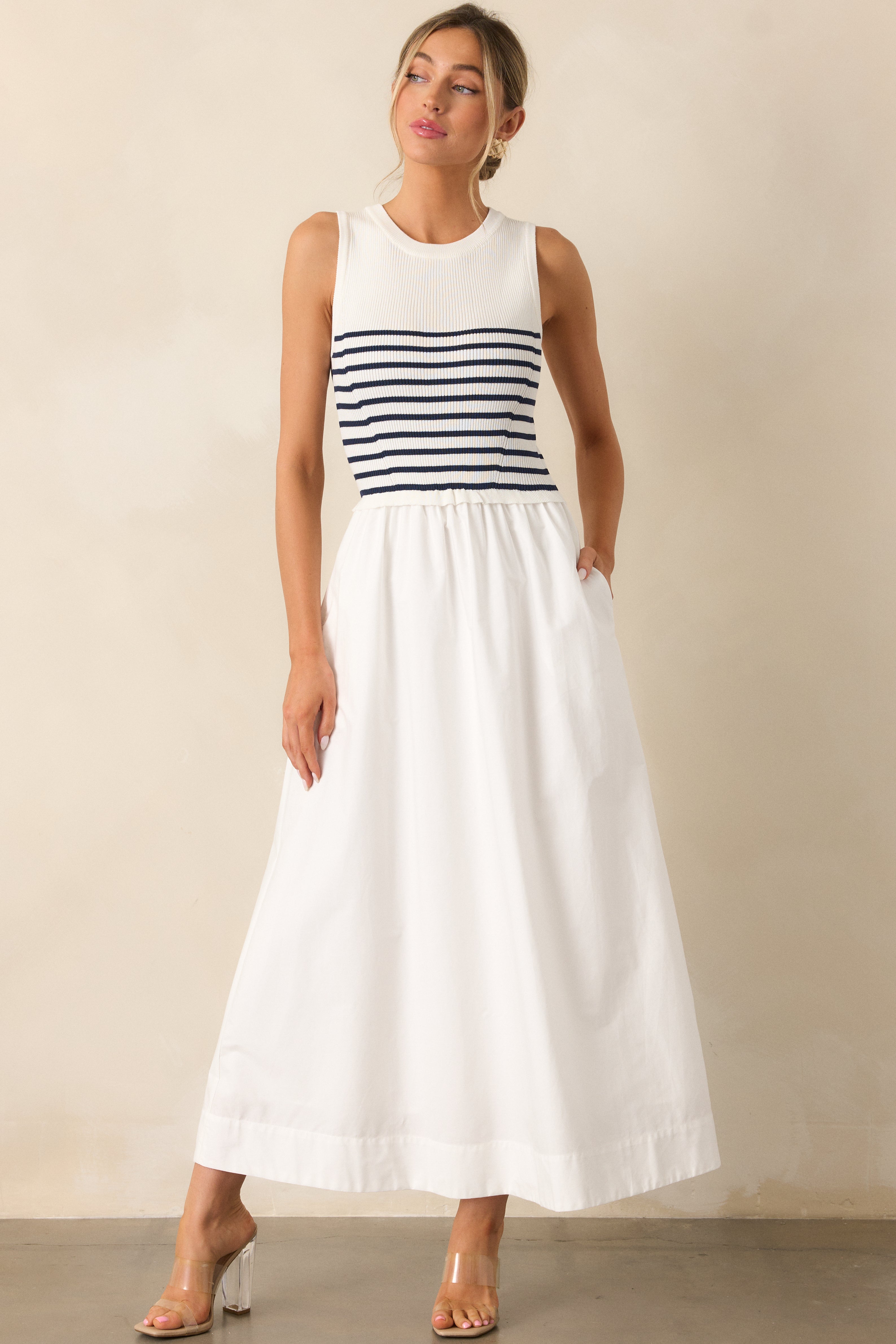 Full view of the white stripe dress focusing on the smooth fabric, fitted bodice, and functional pockets.