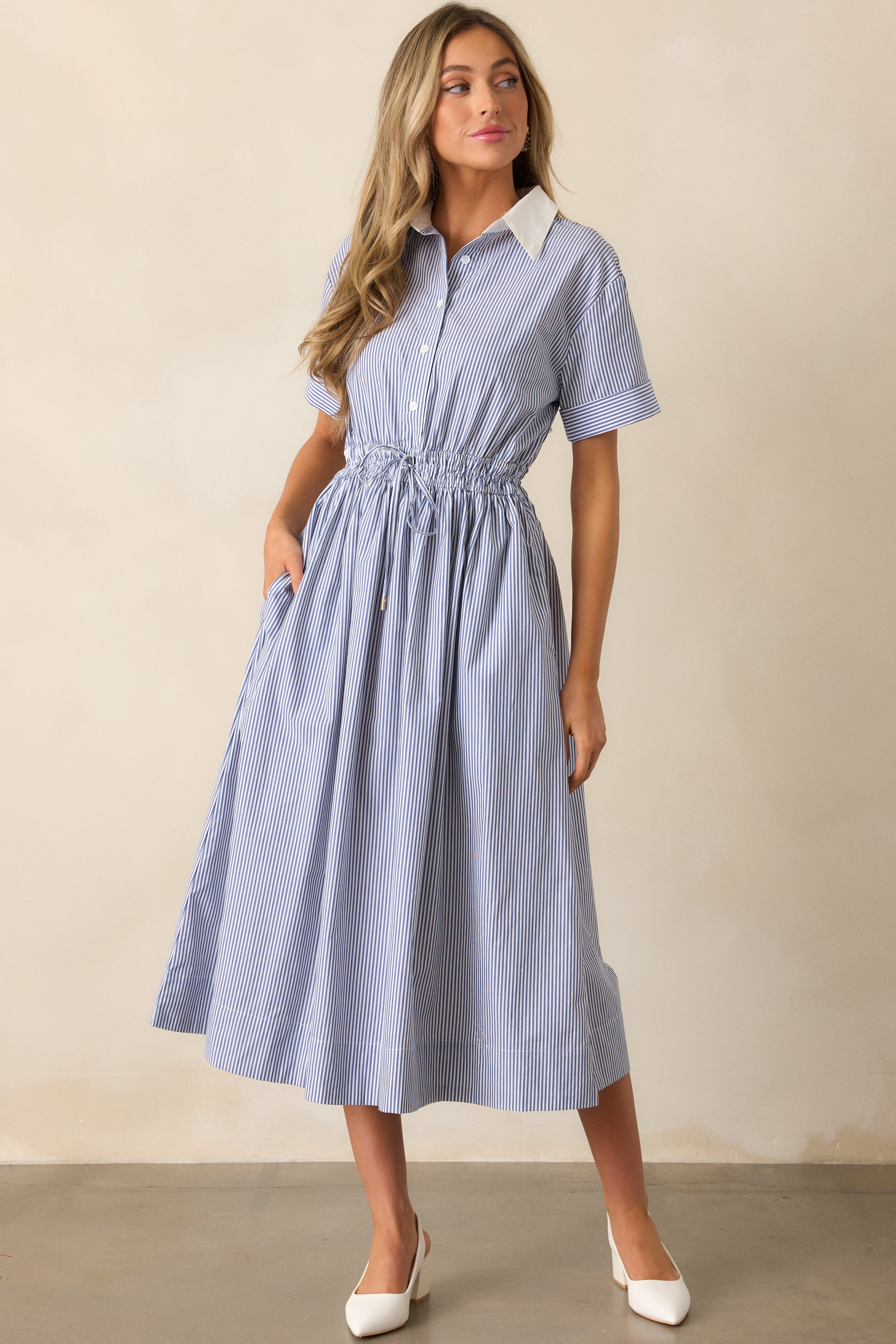 Another front-facing full shot of the blue dress, with a focus on the simple yet elegant design of the collared neckline and pockets.