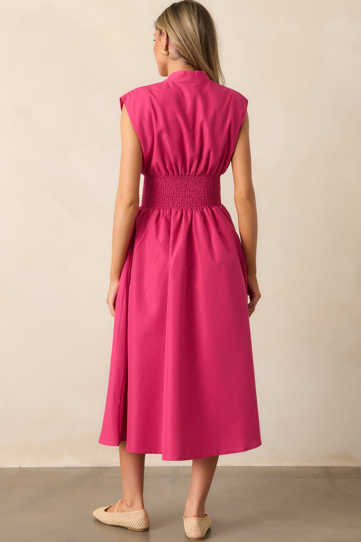 The back of the magenta midi dress, showcasing the smooth fit and capped sleeves without visible fastenings.