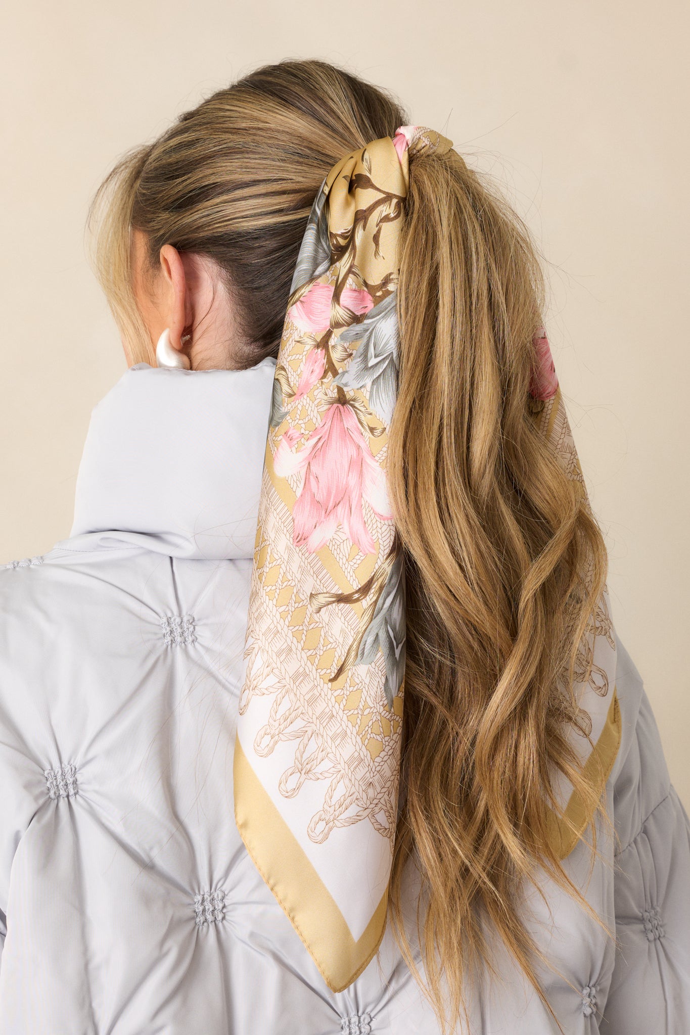 A detailed view of the floral design, with a focus on the intricate pink and blue flowers and the gold trim surrounding the edges.