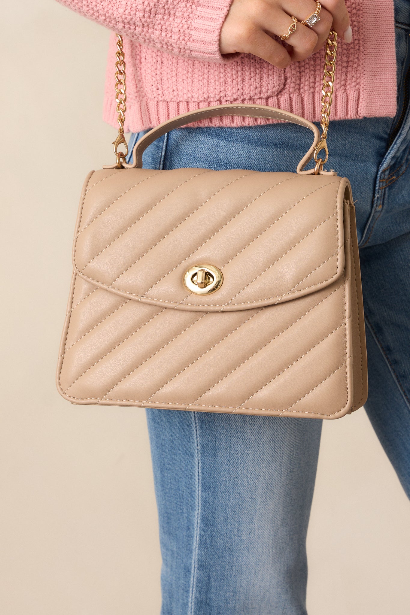 A cropped shot of the handbag from the side, showing the quilted material and the optional gold and mocha shoulder strap, with emphasis on the handbag's structure.