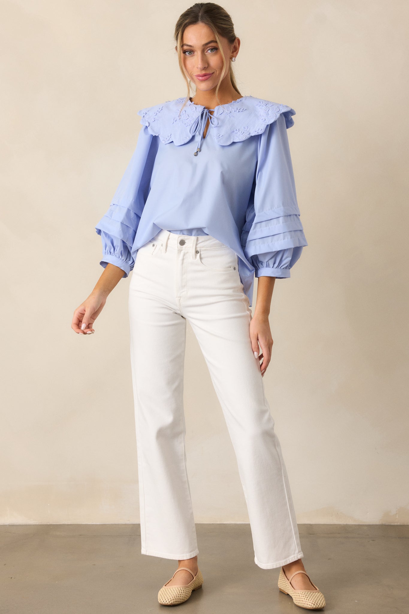 A complete look featuring long puff sleeves with pleated detailing, drawing attention to the fabric texture and the unique sleeve style of the blue blouse.